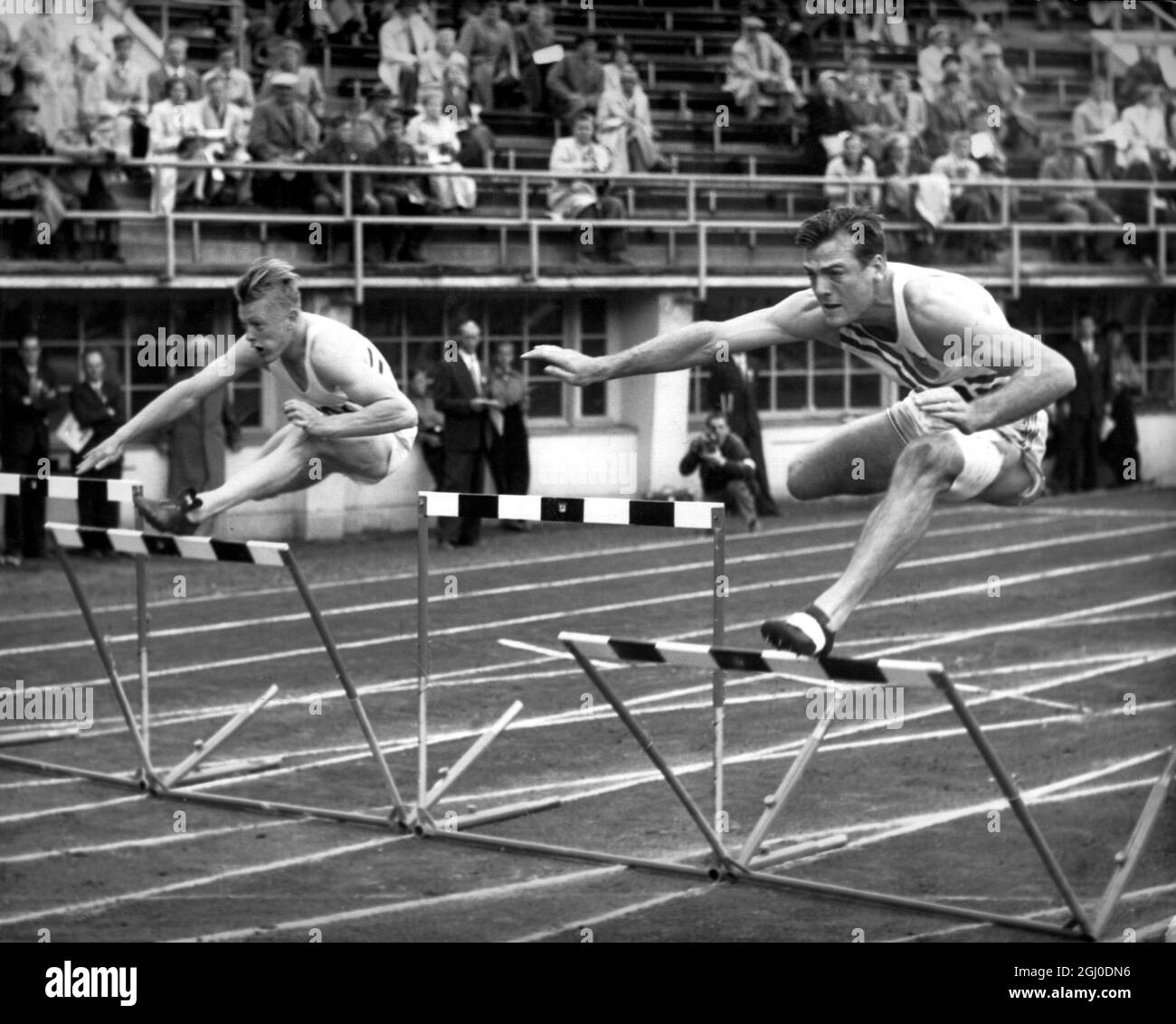 Olympische Spiele 1952 Robert Mathias aus den USA gewinnt die Hitze 8 des Zehnkampf-110-m-Hürdenkampfes von Geoffrey Elliott (Großbritannien) im Olympiastadion, Helsinki, Finnland. Juli 1952. Stockfoto