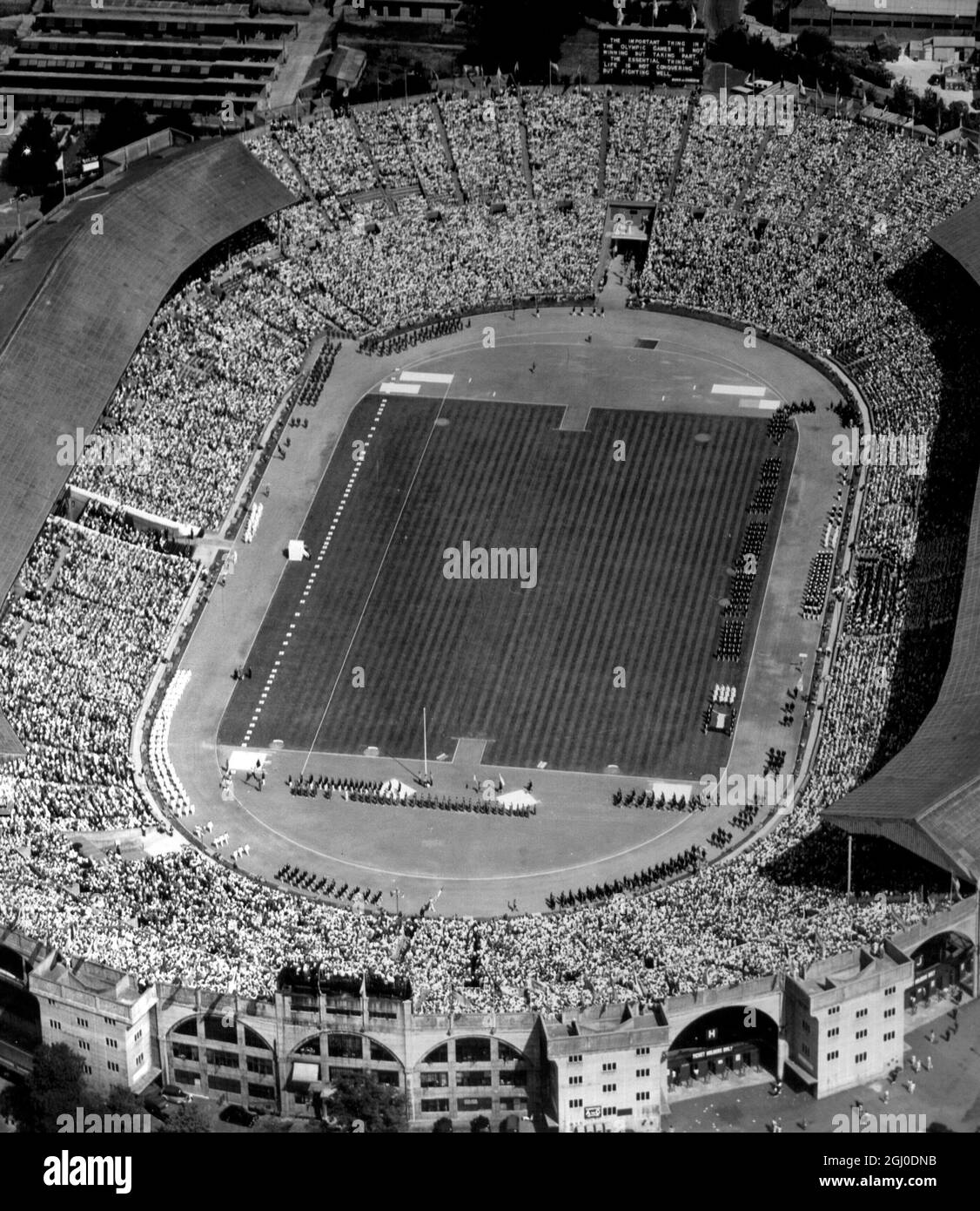 Ein Luftbild der beeindruckenden Szene in Wembley während der Vorbereitungen der Eröffnungszeremonie der Olympischen Spiele.das riesige Stadion ist voll mit über 80,000 Menschen, während die Athleten sich in die grüne Arena einweiden. Juli 1948. Stockfoto