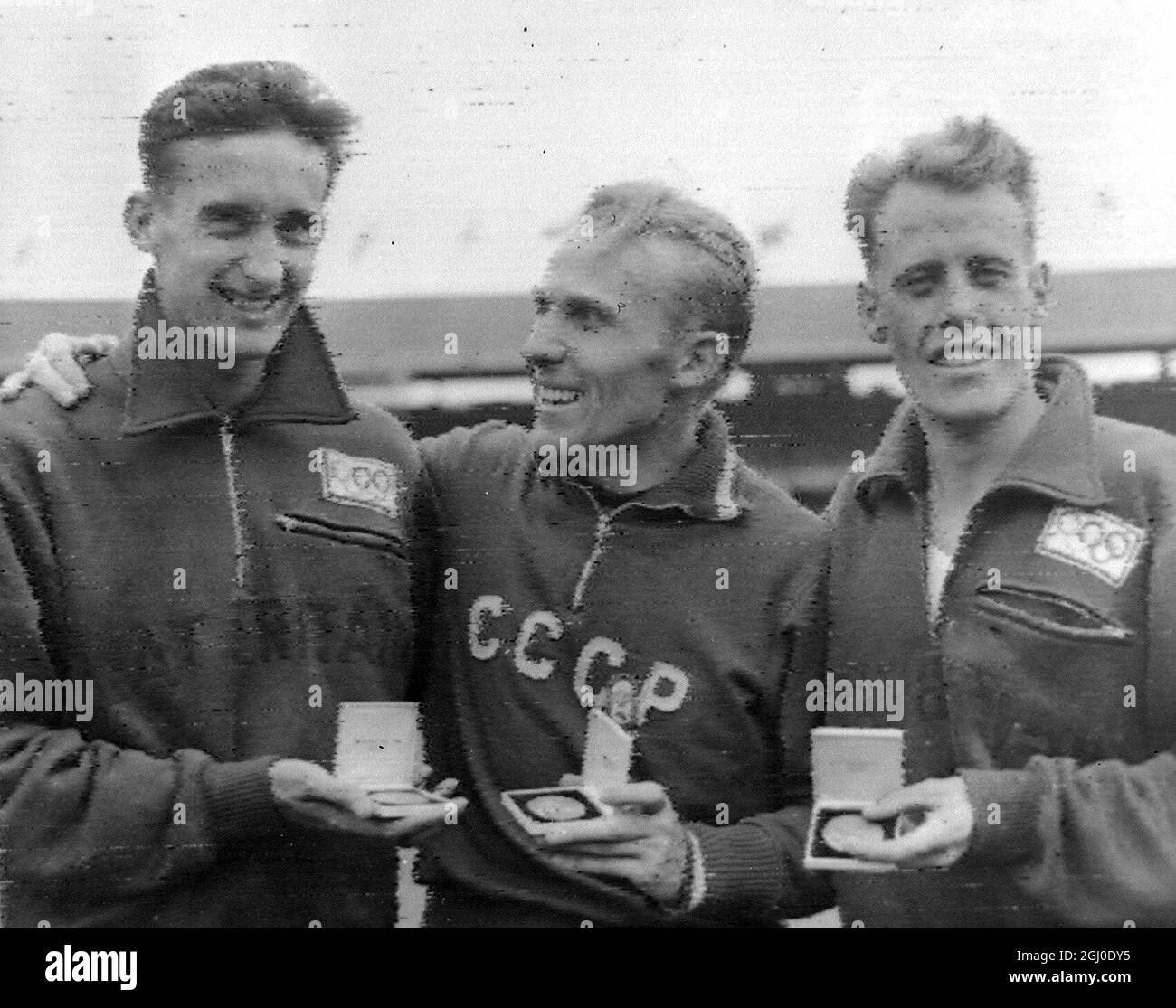 Melbourne Olympic Games 1956 Gewinner des 5000-Meter-Finales Russlands Vladimir Kuts (Mitte) mit seiner Goldmedaille, der Briten Gordon Pirie (links) mit Silber und Derek Ibbotson aus Großbritannien mit der Bronze. November 1956 Stockfoto