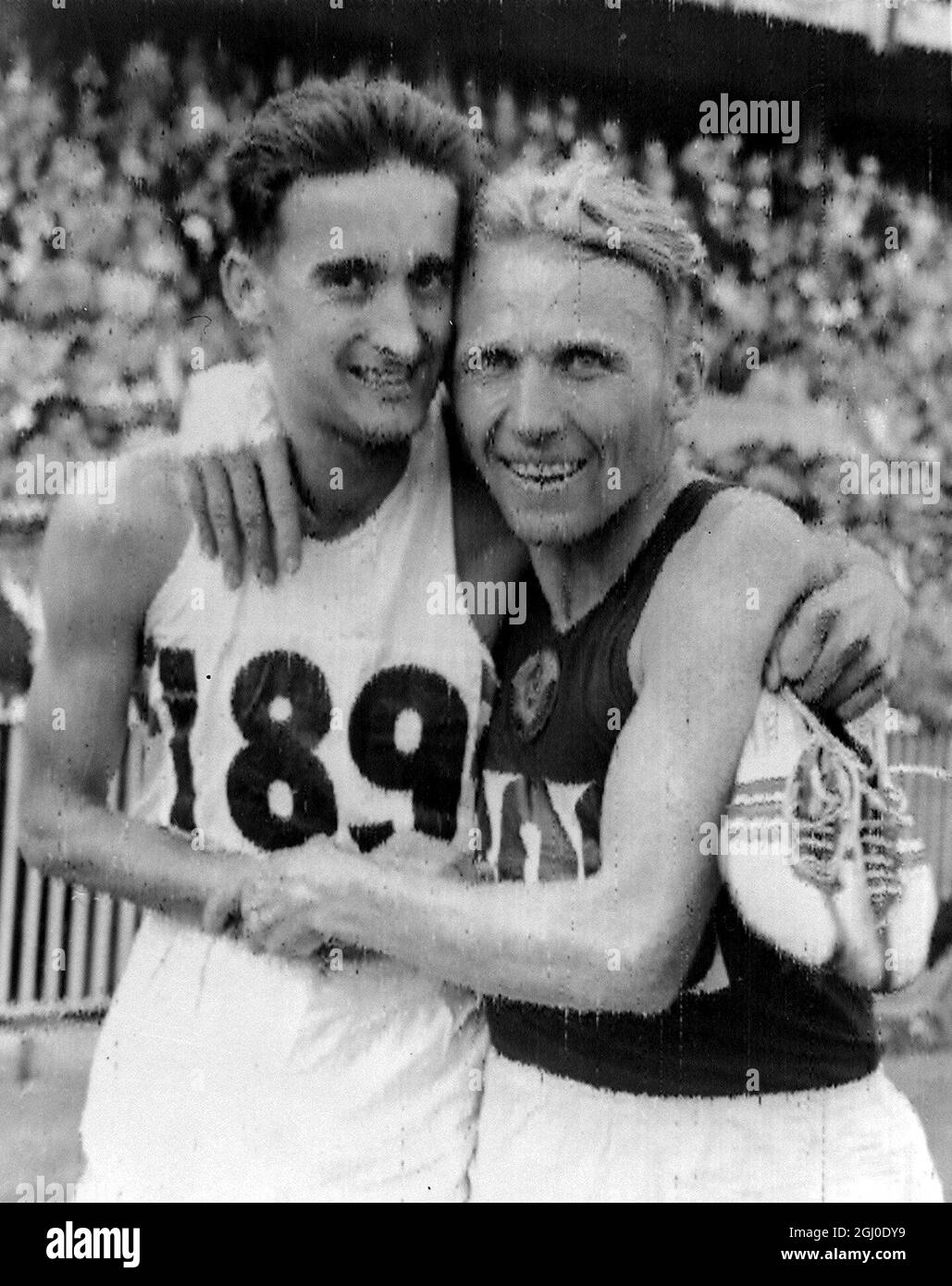 Olympische Spiele in Melbourne 1956 der russische Vladimir Kuts (rechts) und der britische Gordon Pirie Embrace Nachdem Kuts das 5000-m-Finale gewonnen hatte, belegte Pirie den zweiten Platz. November 1956 Stockfoto