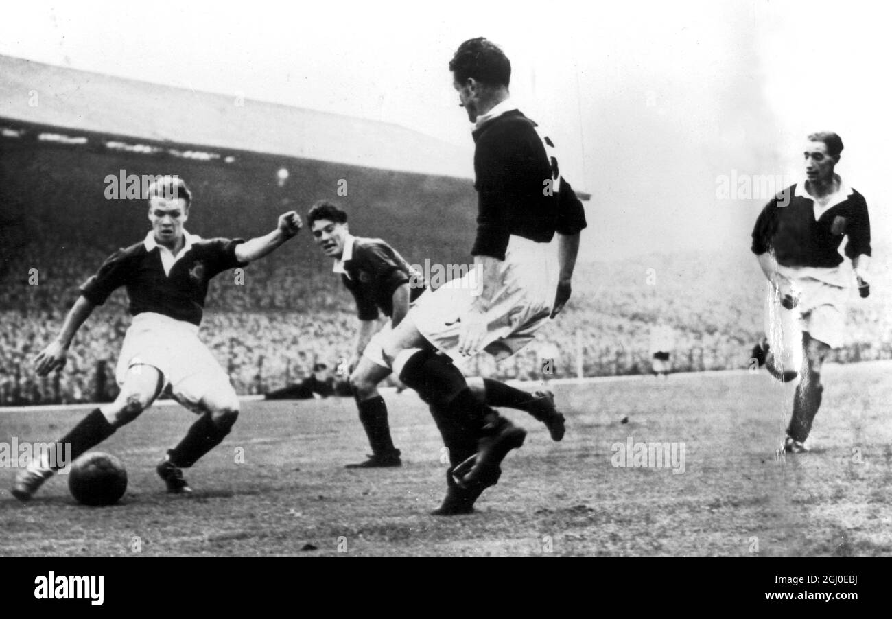 Irland gegen Schottland Billy Bingham, Irlands Ausgesiegter rechts, swerves, um Willie Woodburn, schottische Mittelhälfte (Nr. 5), zu schlagen, nachdem er den Ball von McIlroy (zweiter von links) erhalten hat, als Cox, Schottlands linker Rücken (rechts), einläuft, um abzufangen - während des Spiels von Ireland Scotland International im Windsor Park, Belfast. Schottland gewann das Spiel mit drei Toren auf Null. Oktober 1951. Stockfoto