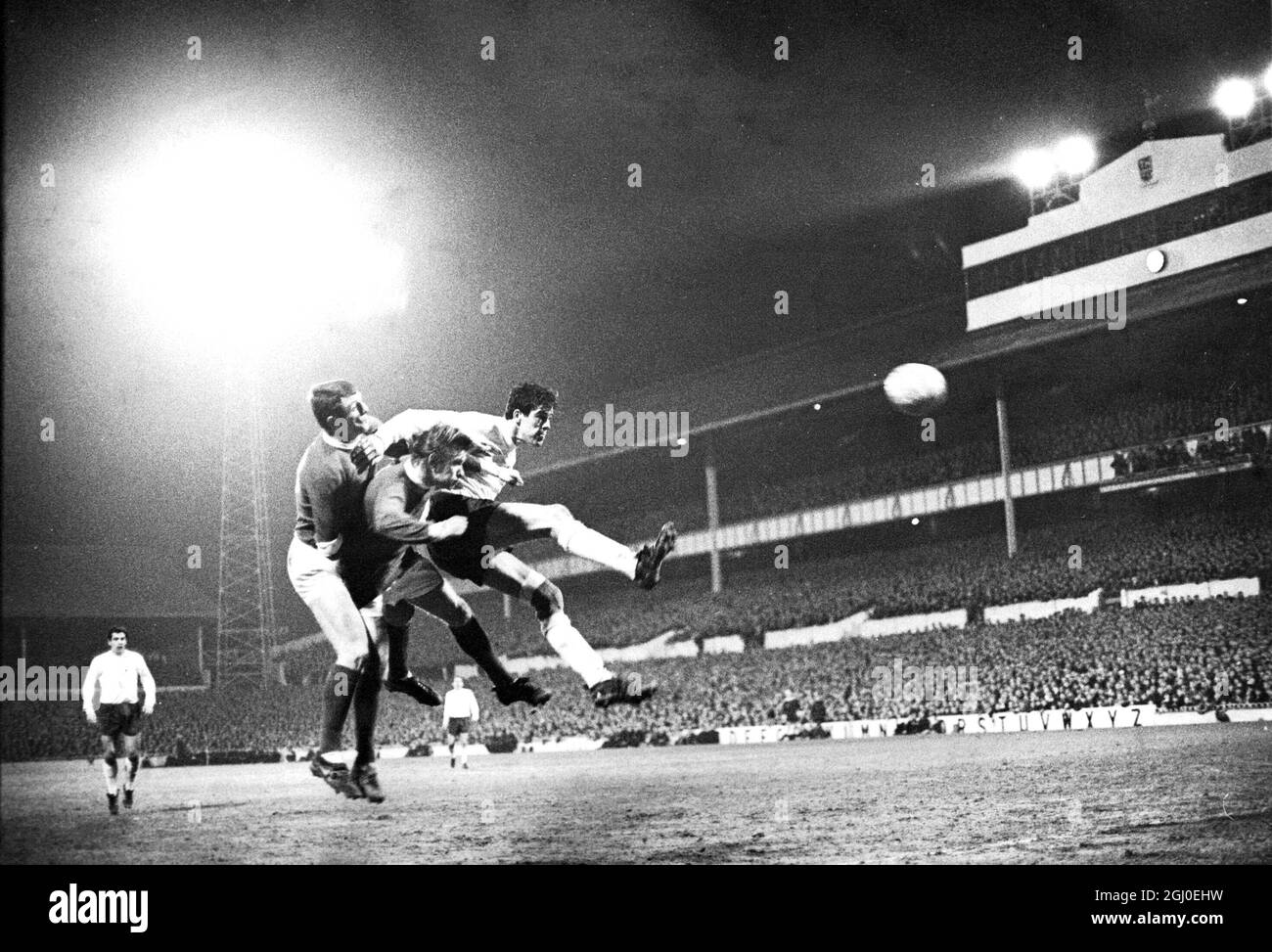 Tottenham Hotspur gegen Manchester United Mike England (Spurs) im weißen Hemd schlägt zwei Manchester United-Spieler in einem Midair-Kampf während der dritten Runde des FA Cup in der White Hart Lane. Januar 1968. Stockfoto