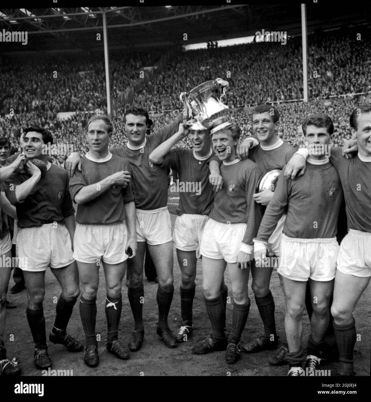1963 FA Cup Finale Manchester United V Leicester City nach der Übergabe der Trophäe und Medaillen durch H.M The Queen zeigen Manchester United Kapitän und Mitglieder des Teams stolz den Pokal der Menge. Von links nach rechts: Außen links Bobby Charlton, links hinten und Kapitän Noel Cantwell, rechts Pat Crerand, innen rechts Albert Quixall mit der Tasse ausgeglichen auf seinem Kopf und Mitte vorwärts David Herde. Mai 1963. Stockfoto
