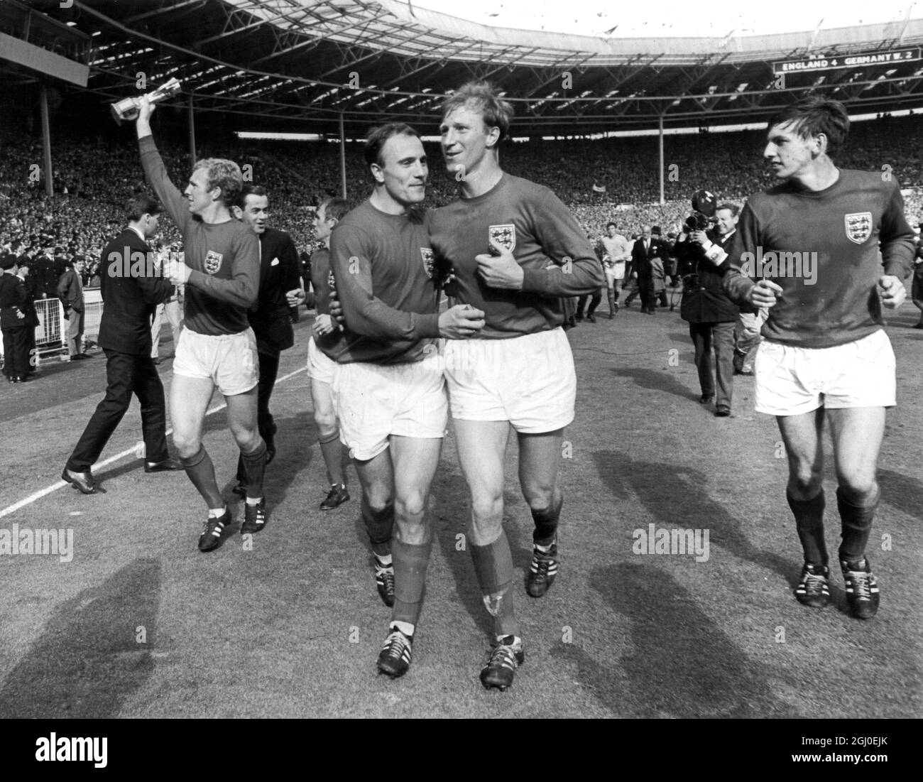 1966 WM-Finale England gegen Westdeutschland die Spieler feiern mit einer Ehrenrunde nach ihrem Sieg gegen Westdeutschland im Finale. Von links nach rechts: Bobby Moore (Kapitän), George Cohen, Jack Charlton und Martin Peters. Juli 1966. Stockfoto