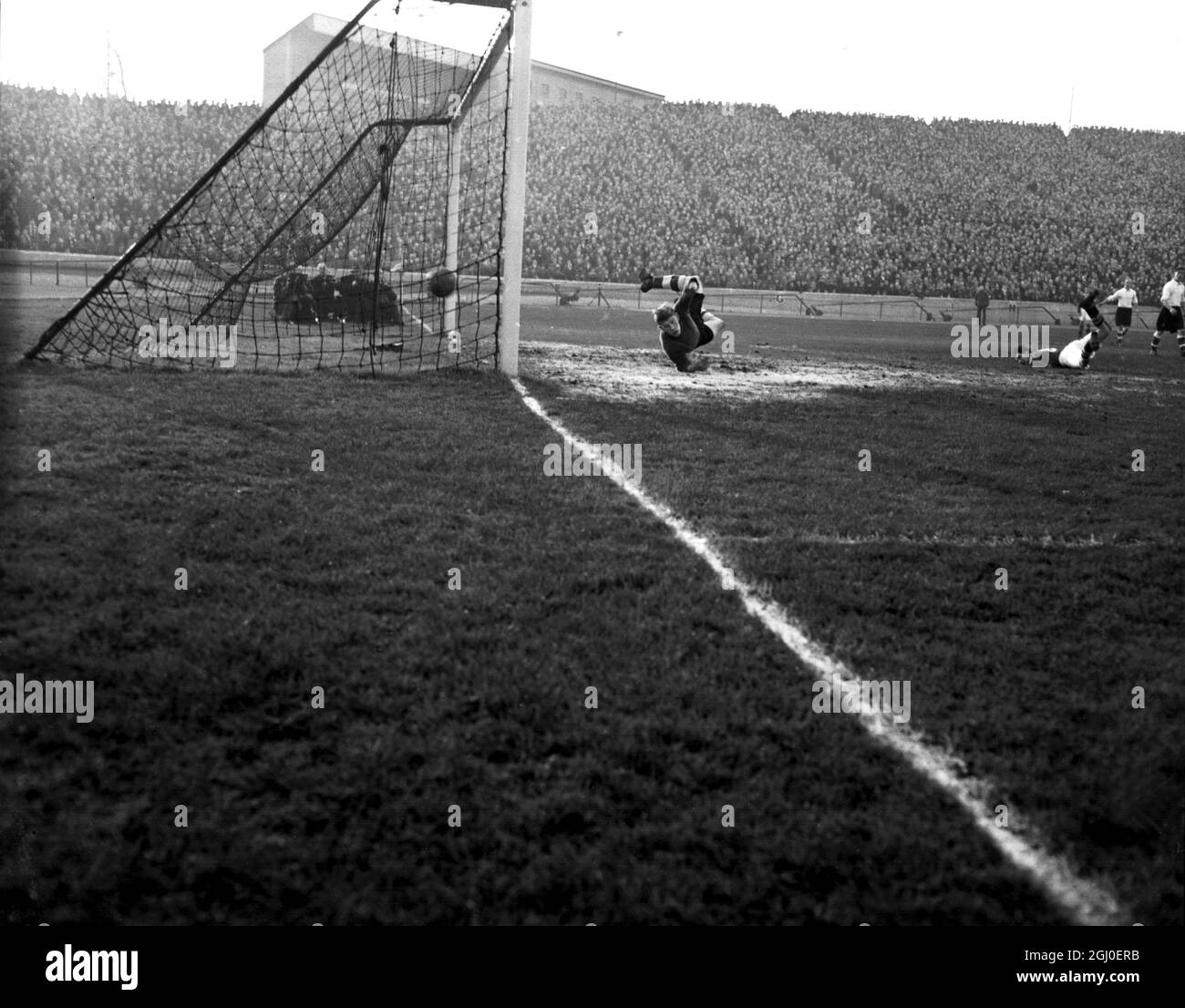 FA Cup 3. Runde Chelsea gegen Chester City Chelsea Center Forward D'Arcy führt den Ball ins Tor, während Chester Torhüter Threadgold versucht, während des dritten Runden-Spiels von Chelsea gegen Chester FA Cup in Stamford Bridge zu retten. Obwohl der Ball ins Netz ging, wurde er nicht zugelassen, da D'Arcy abseits stand. Januar 1951. Stockfoto