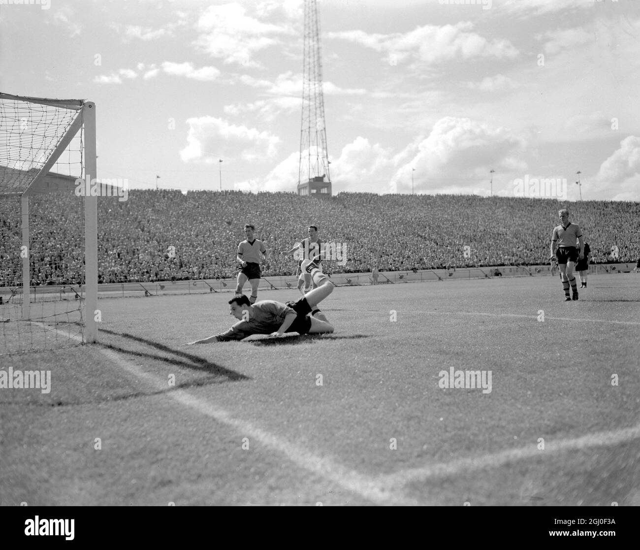 Chelsea gegen Wolverhampton Wanderers Wolves Torhüter Sidebottom springt während des Spiels an der Stamford Bridge von Chelseas Mittelstürmer Livesey ab. Im Hintergrund sind (rechts) Chelseas innen rechts Jimmy Greaves und (links) Harris, die Wölfe links hinten. August 1960. Stockfoto