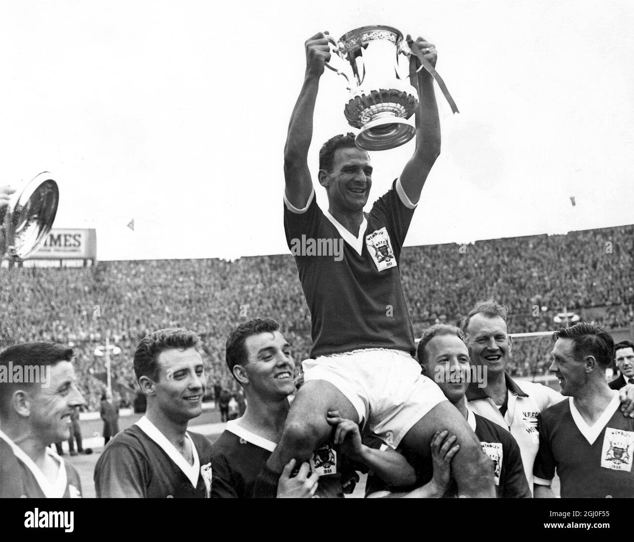1959 FA Cup Finale Nottingham Forest gegen Luton Town Jack Burkitt der Kapitän des Nottingham Forest hält stolz den FA Cup hoch, während er nach dem Sieg gegen Luton von seinen Teamkollegen geleitet wird. Mai 1959. Stockfoto