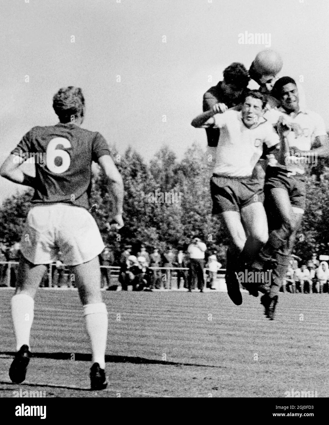 Portugal gegen England der englische Boby Moore (links) sieht zu, wie die portugiesischen Spieler Jose Augusto (vorne links) und Eusebio (rechts) während des Spiels in Lissabon, Portugal, um den Ball herausfordern. Mai 1964. Stockfoto