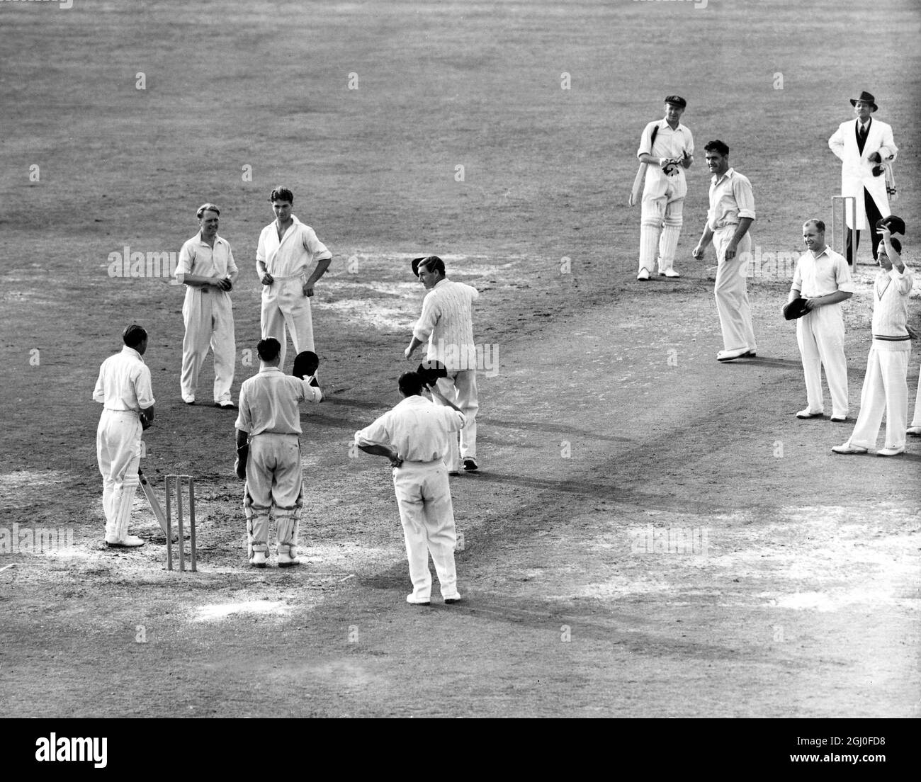England gegen Australien Don Bradman wird von der englischen Mannschaft angefeuert, als er in seinem letzten Testspiel beim Oval herauskommt, um zu schlagen. Unmittelbar danach wurde er von Hollies für eine Ente geduckt. August 1948. Stockfoto