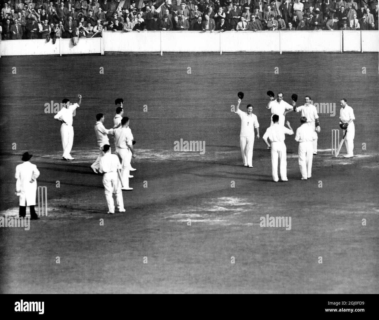 England gegen Australien Don Bradman wird von der englischen Mannschaft angefeuert, als er in seinem letzten Testspiel beim Oval herauskommt, um zu schlagen. Unmittelbar danach wurde er von Hollies nach einer Ente geduckt. August 1948. Stockfoto