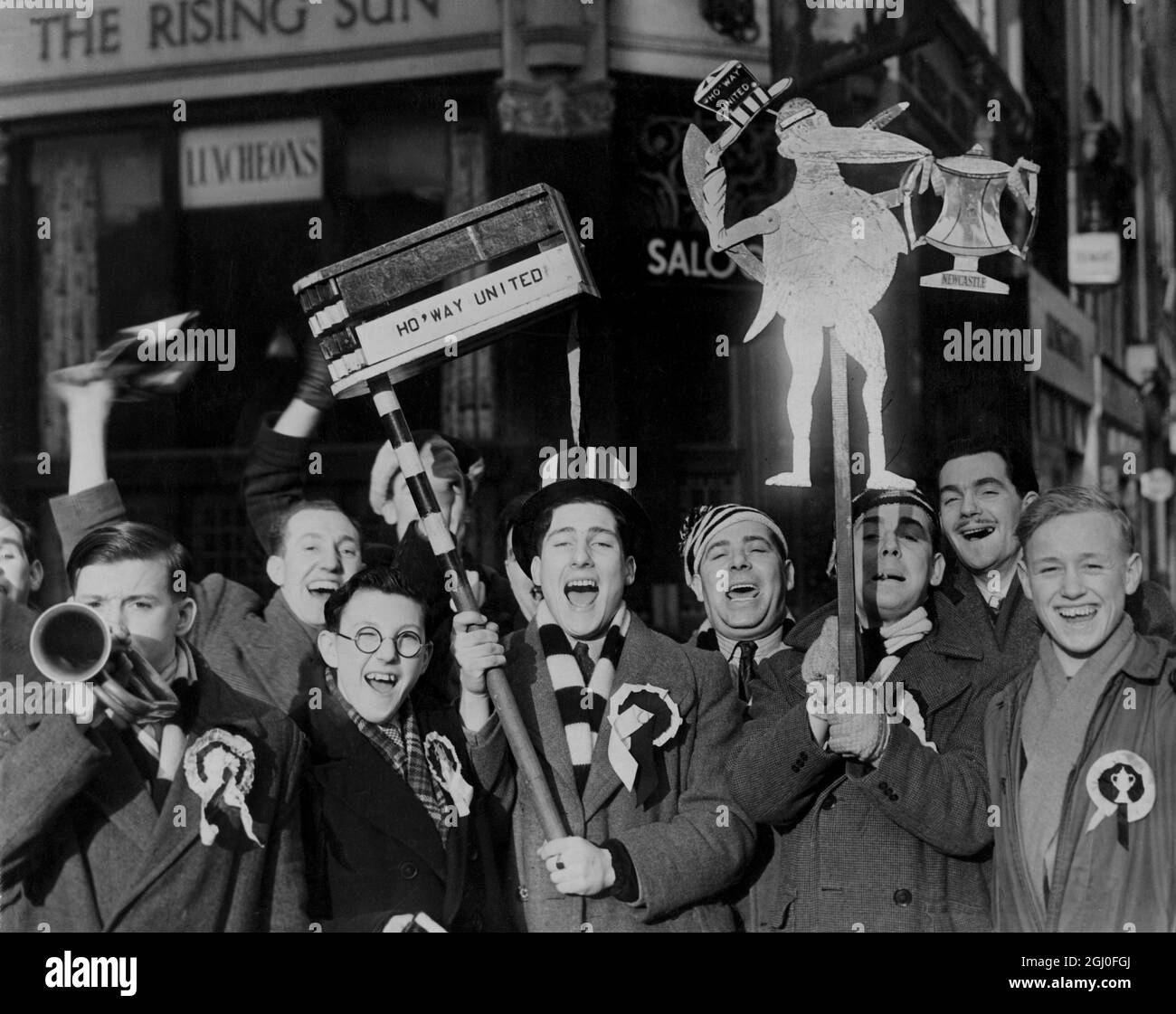 Newcastle Supporters bringen ihren Cup mit Tausende von Fans von Newcastle United kamen heute Morgen nach London, um ihr Team in der 4. Runde der F.A. Tottenham Hotspors spielen zu sehen Becher. Fotoausstellungen: Eine Gruppe von Newcastle United-Anhängern, die bei ihrer Ankunft an der King's Cross-Station mit gigantischem Rassel und Maskottchen, komplett mit Tasse, fotografiert wurden. Februar 1952 Stockfoto