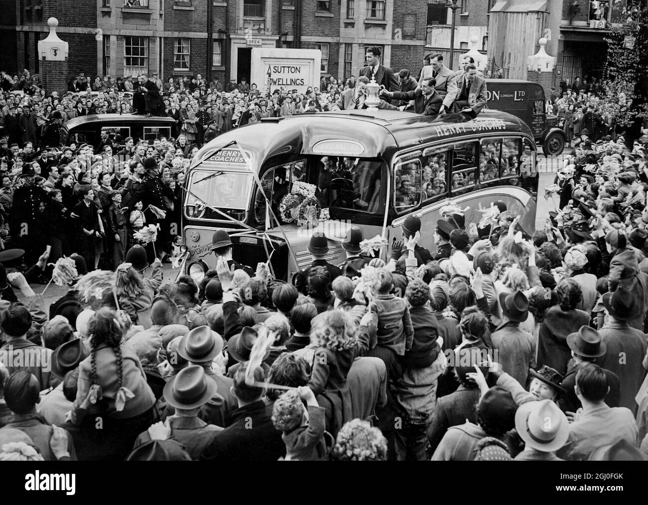 Das Arsenal Football-Team, Sieger des Pokalfinales am Samstag in Wembley, wurde vom Bürgermeister und der Corporation of Islington im Rathaus empfangen. Das Bild zeigt den Reisebus mit Teammitgliedern und Kapitän Joe Mercer, der den Pokal hält, auf seinem Weg durch die jubelnden Massen zum Rathaus. Mai 1950 Stockfoto