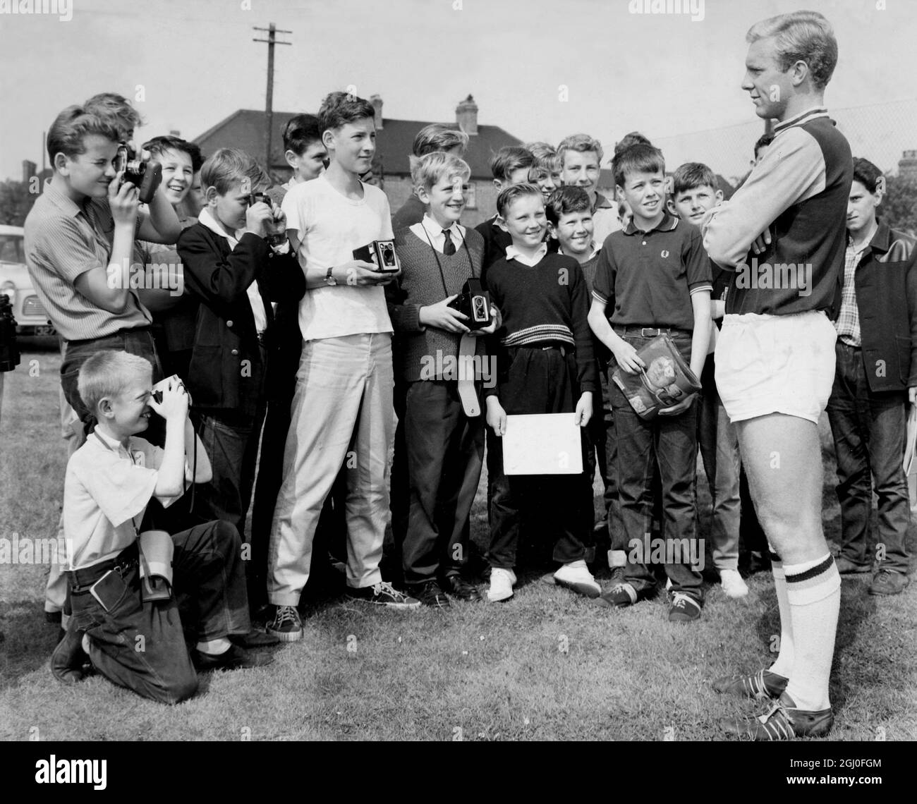 Die Fußballspieler von West Ham United trainieren jetzt auf ihrem neu erworbenen Gelände in Chadwell Heath, Essex, für die kommende Saison. Fotographie zeigt - junge Bewunderer fotografieren ihr Idol Bobby Moore. August 1962 Stockfoto