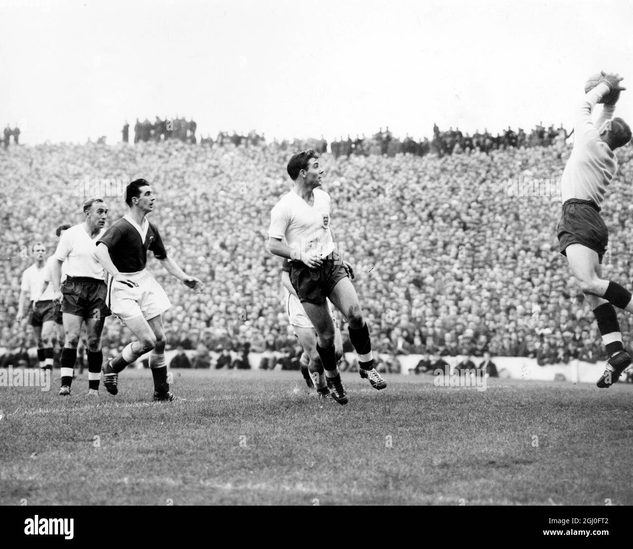 Wales gegen England Wright, Vernon und edwards beobachten, wie Hopkinson während des Spiels in Cardiff, das England durch Tore auf Null gewann, einen hohen Ball kath. Oktober 1957 Stockfoto