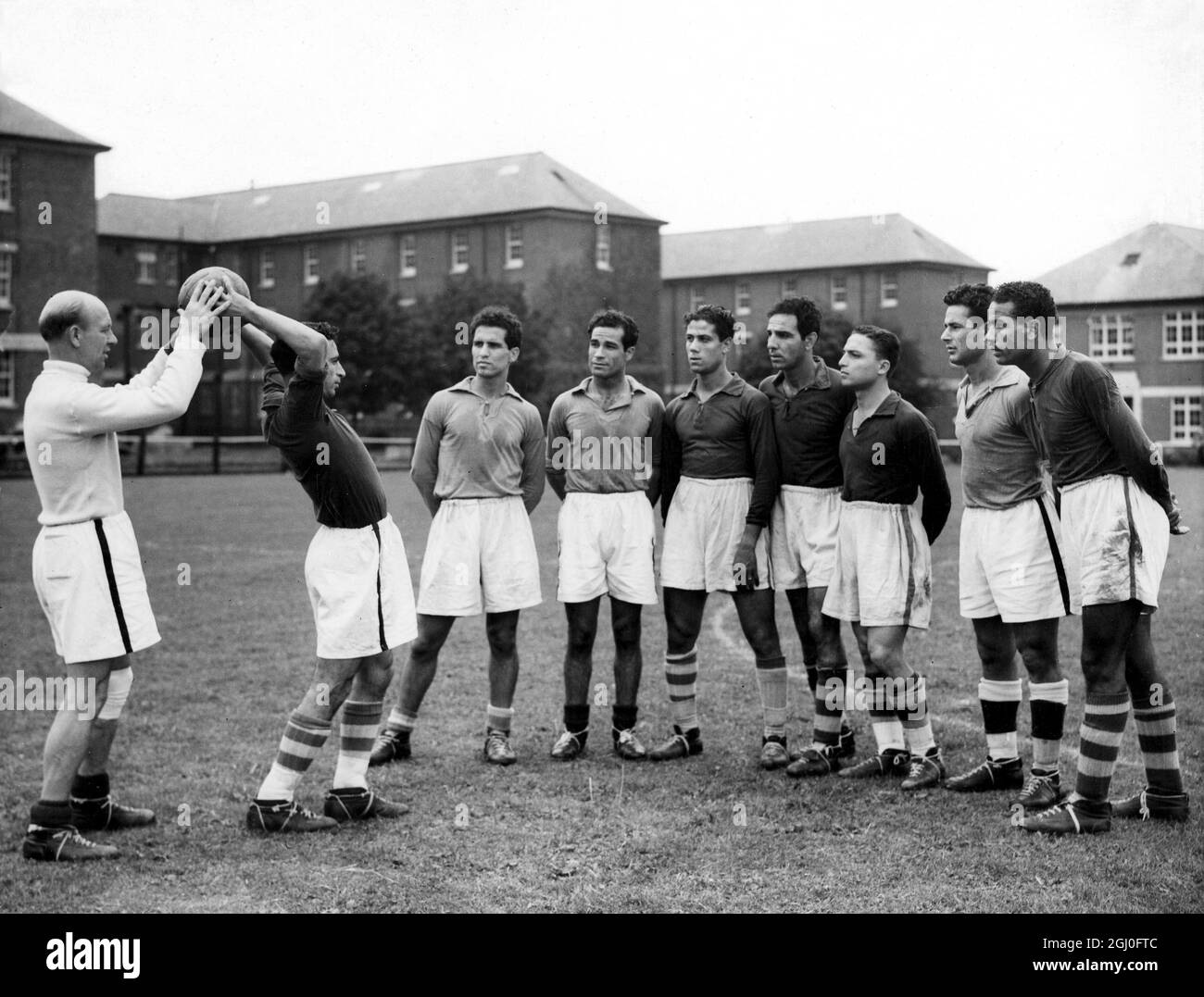 Eric Keen , der alte Derby County Spieler und jetzt Trainer der ägyptischen Fußballmannschaft, zeigt den Spielern, wie man beim Training in Uxbridge einen Wurf macht. Juli 1948. Stockfoto