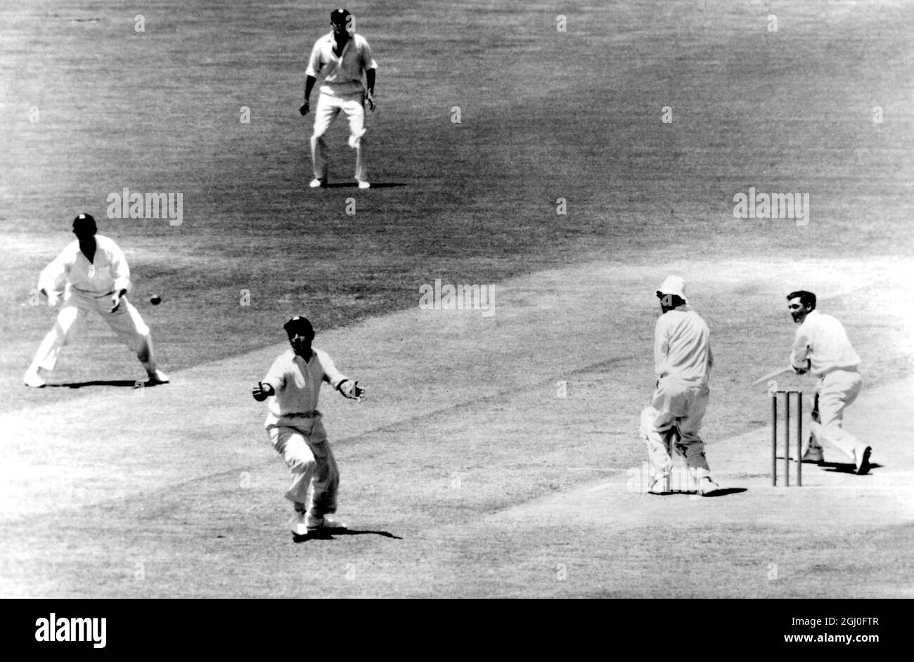 Australien gegen England Linkshänder der australische Schlagmann Neil Harvey wird von Colin Cowdrey beim Bowling von Ray Illingworth während der ersten Innings Australiens gegen England im vierten Testspiel in Adelaide fallen gelassen. Januar 1963. Stockfoto