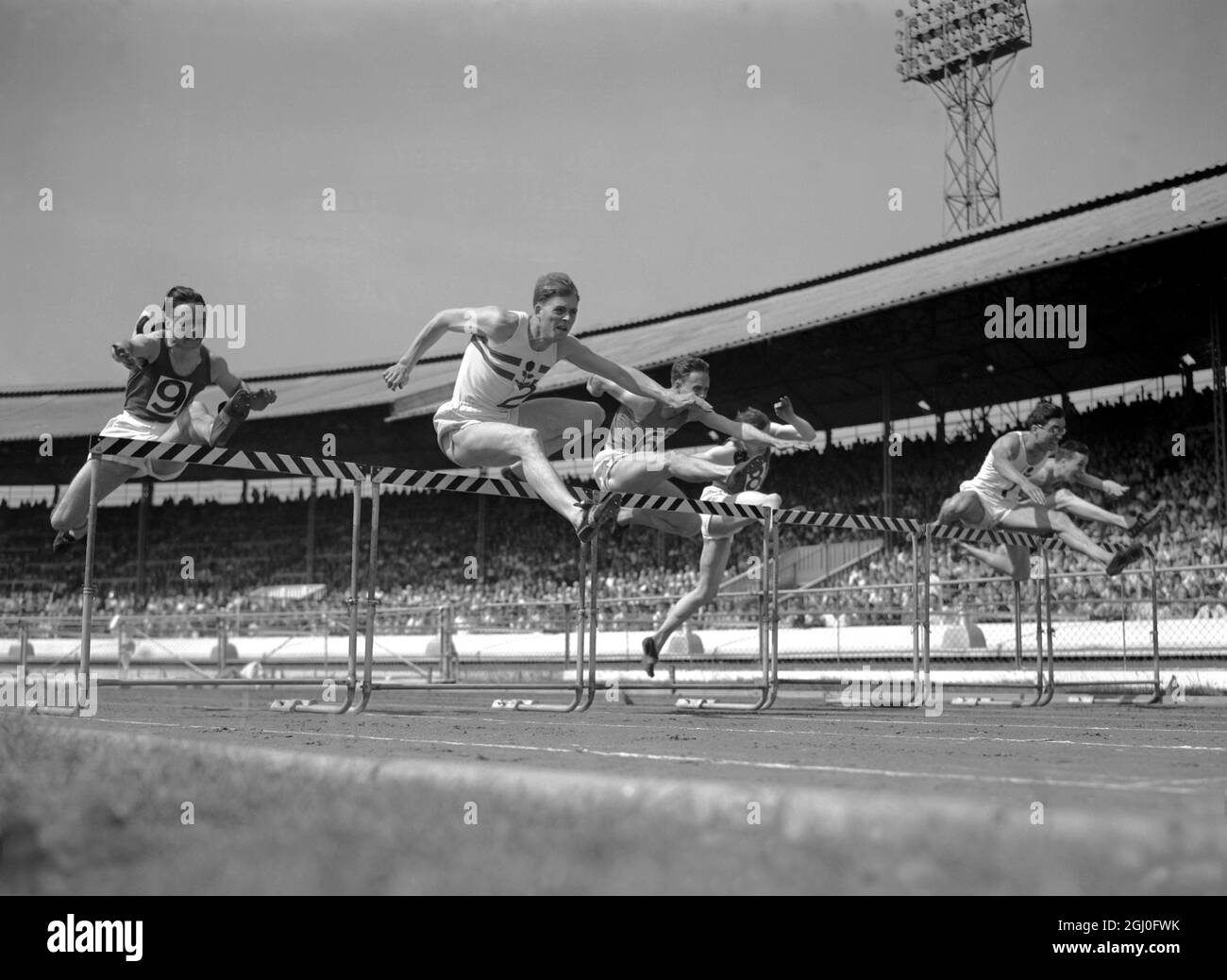 Eine Hürde beim International Athletics Meeting 110 Meter (Dreiecksveranstaltung) von links nach rechts J P McAslan (Scotland Edinburgh Southern Harriers) F J Parker (England South London Harriers), der Zweiter wurde. J C McVeigh ( Cambridge University) J G M Hart ( Scotland RAF & Atlanta A C ), der (Nr. 8) Dritter wurde und P B Hilreth (England Polytechnic Harriers) der Gewinner 5. Juli 1952 Stockfoto