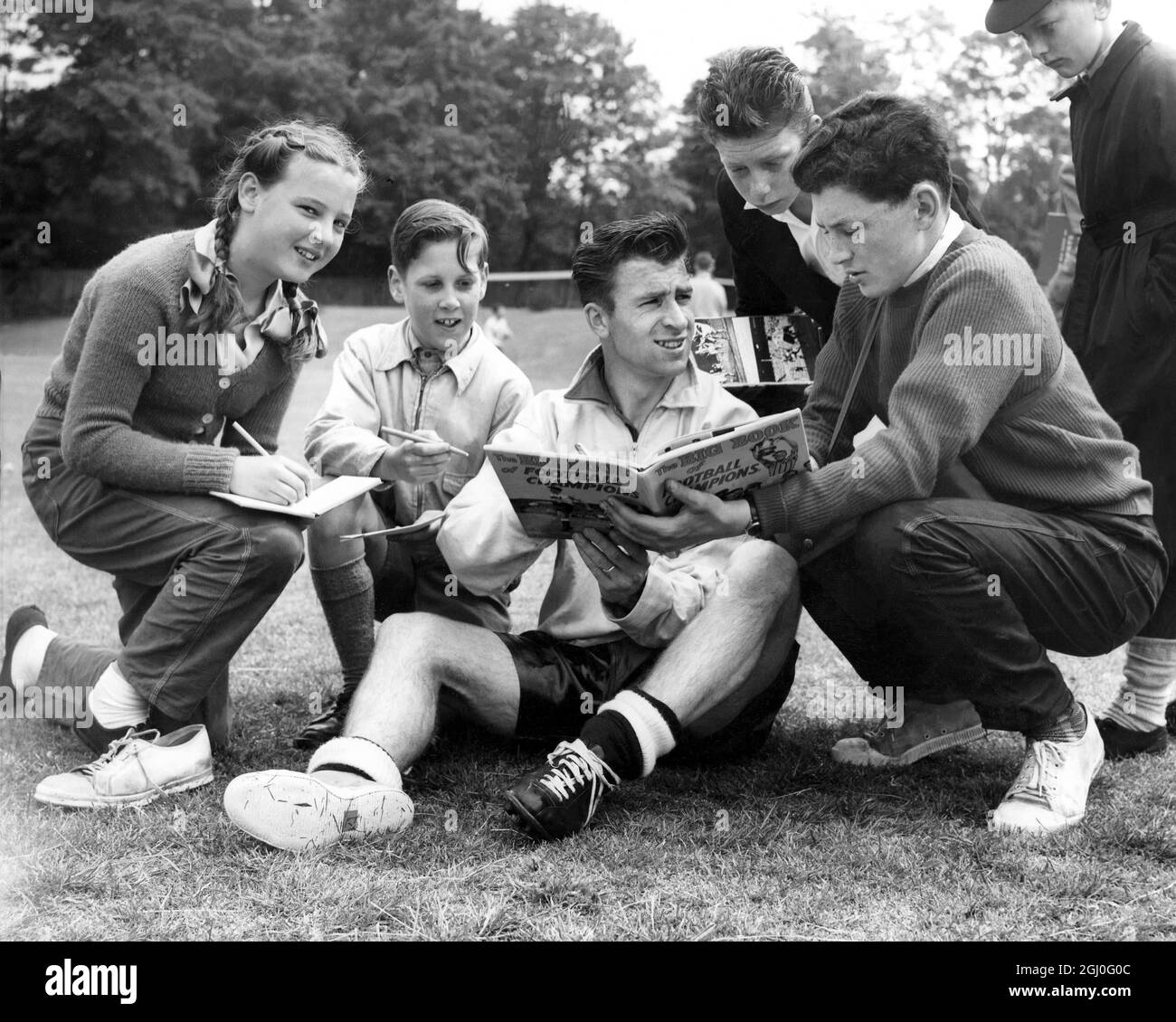 Bryan Douglas, der Stürmer von Blackburn und England, signiert Autogramme, während er während eines WM-Trainings in Roehampton seine Stiefel auswechselt. Mai 1958 Stockfoto