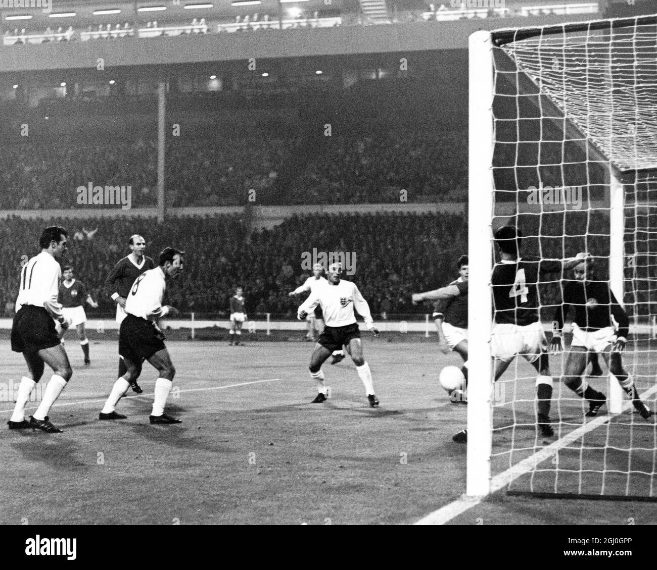 England gegen Österreich Jimmy Greaves (Nr. 8) steht auf dem Tor, beobachtet von anderen Englands Stürmer, John Connelly und Barry Bridges, aber der Ball wurde von österreichischen Verteidigern geräumt. England wurde 3-2 von der jungen, experimentellen österreichischen Mannschaft geschlagen. Oktober 1965 Stockfoto
