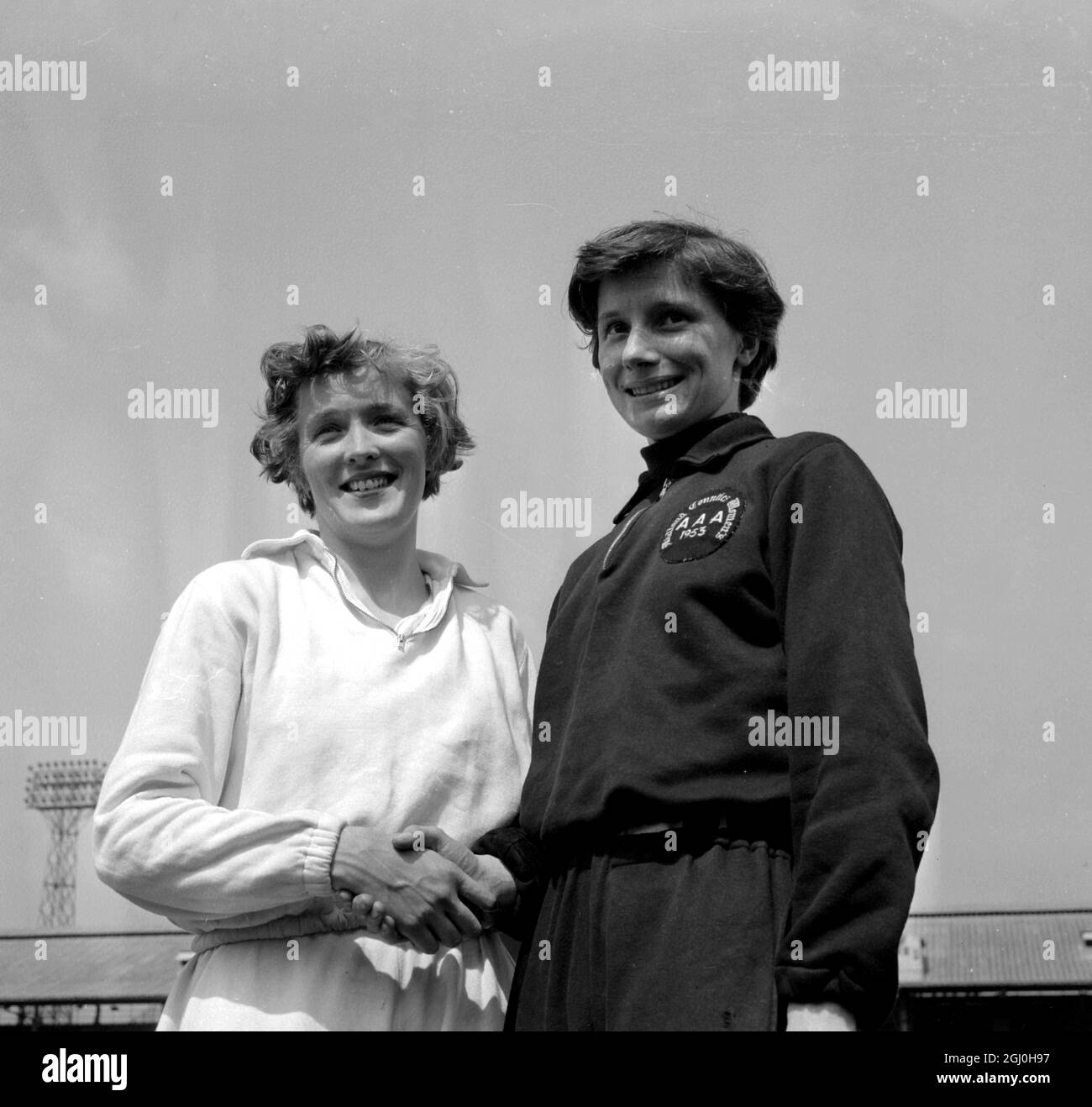 London: Valerie Winn, formell 880-Meter-Weltrekordlerin (links) mit Diana Leather, einer 21-jährigen Tochter aus Birmingham, nachdem sie in 2 Minuten den Weltrekord aufgestellt hatte, als sie die halbe Meile gewann. 9 Sekunden bei der AAA-Meisterschaft der Frauen in White City. 19. Juni 1954 Stockfoto