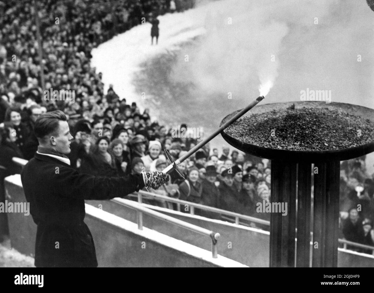 Olympische Winterspiele 1952 - Oslo, Norwegen Eigil Nansen, der Enkel des großen Entdeckers Frithjof Nansen, zündet zur Eröffnung der Olympischen Winterspiele im Bislet-Stadion in Oslo die olympische Flamme an. - 15. Februar 1952 - ©TopFoto Stockfoto