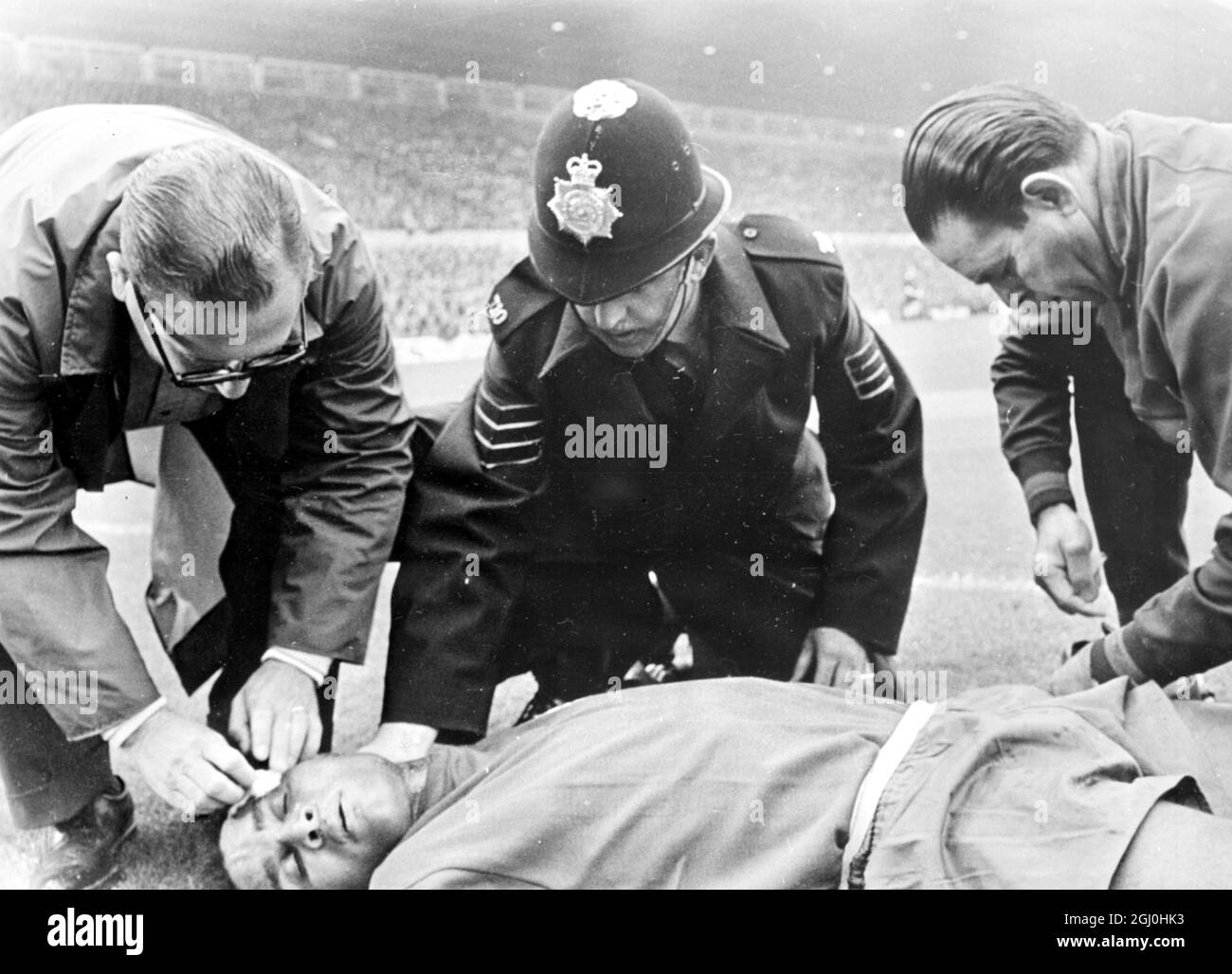 1966 WM Portugal gegen Ungarn. Der Portugiesen Eusebio wird von Beamten und einem Polizisten aufmerksam gemacht, nachdem er während des Spiels verletzt wurde. Portugal gewann 3:1. Juli 1966 Stockfoto