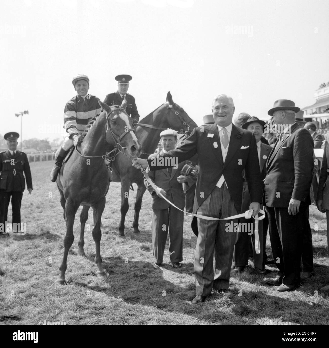 Epsom, Surrey, England: Strahlend vor Freude führt der New Yorker Raymond Guest in seinem Pferd Larkspur mit dem australischen Jockey Neville Sellwood im Sattel, nachdem er heute hier den 183. Derby-Einsatz gewonnen hatte. Der zweite war Arcor, im Besitz des französischen Textilmagnaten Marcel Boussac und unter der Leitung von roger Poinzelet, und der dritte war Le Cantilien, im Besitz von Mme Suzy Volterra und unter der Leitung von Yves Saint-Martin. 6. Juni 1962 Stockfoto