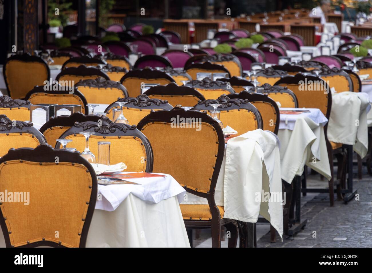 Reihe leerer Stühle und Tische im Restaurant im Freien. Keine Personen Stockfoto