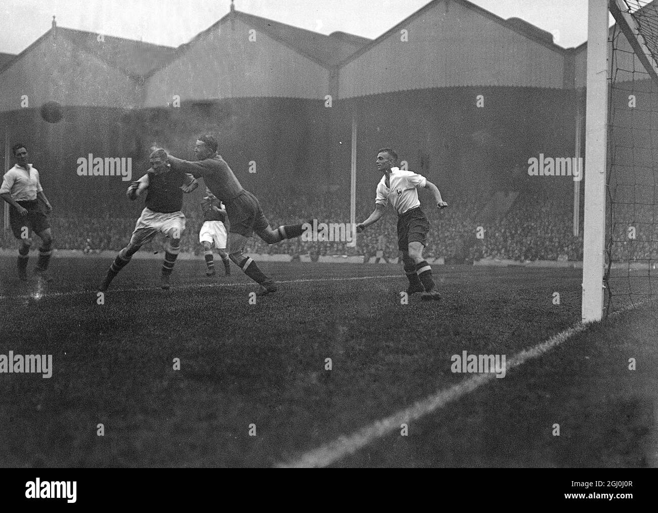 Eine riesige Menschenmenge beobachtete Arsenal und Tottenham Hotspur, als sie sich in ihrem London Derby in Highbury trafen. Nichells, Torhüter von Spurs, hat Drake einen harten Schuss ausgestoßen. 20. Oktober 1934 Stockfoto