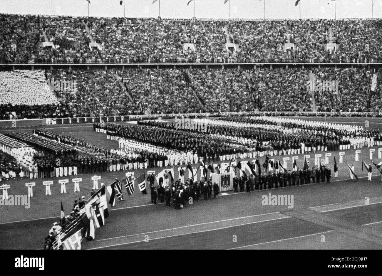 Olympia 1936, Berlin - der Bannerträger der vereinten Nationen bildete einen Halbkreis, während Ruydolf Ismayr den olympischen Eid schwor. (Die Fahnenträger der Nationen schlossen sich zu einem Halbkreis zusammen, und Rudolf Ismayr leistete den Olympischen Eid) ©TopFoto Stockfoto