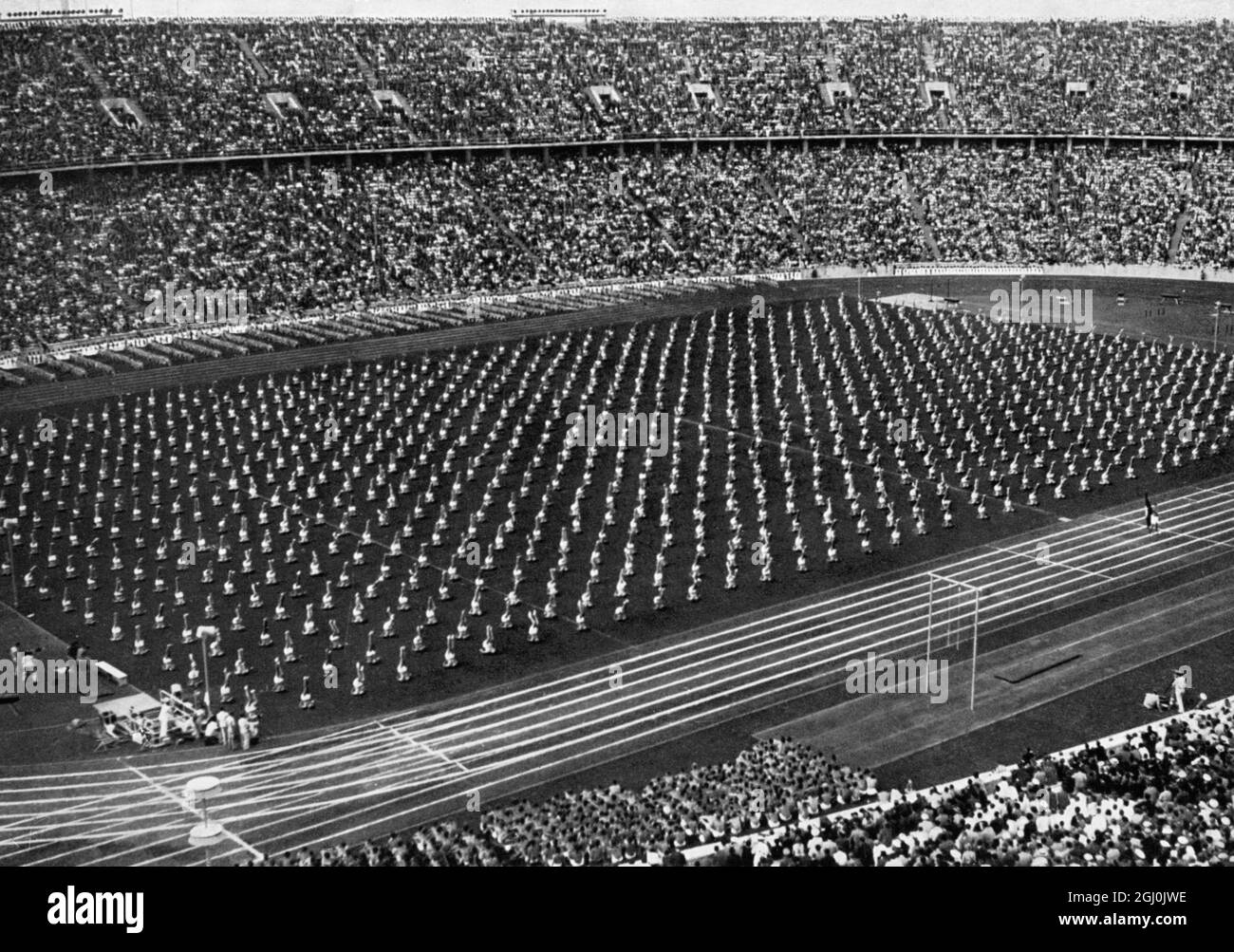 Olympia 1936, Berlin - die Turnroutine der Deutschen im vollen Olympiastadion hinterließ einen starken Eindruck. (Die praktischen Gymnastik-Vorführungen der deutschen Turner im vollbesetzten Olympiastadion hinterlassen einen starken Eindruck.) ©TopFoto Stockfoto