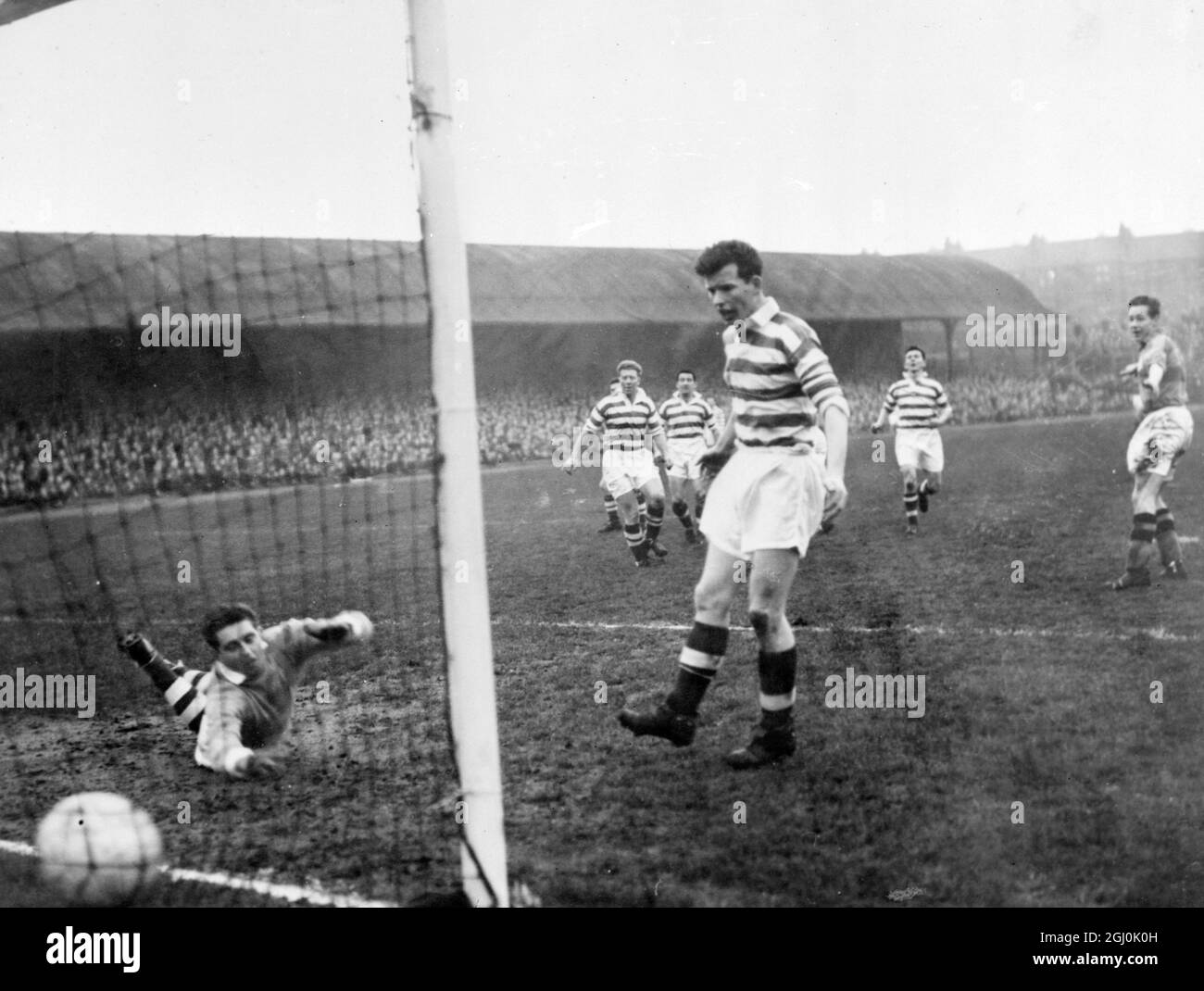 Ibbrox Park, Glasgow: Das erste Tor von Partick Thistle, das Mathers (rechts) und McPhail (Mitte) von Celtic erzielt haben, sieht zu, wie der Ball während des Celtic gegen Partick Thistle an seinem Torwart Beattie vorbeigeht. Partick schlug Celtic mit drei Toren zu zwei. 22. Dezember 1957 Stockfoto