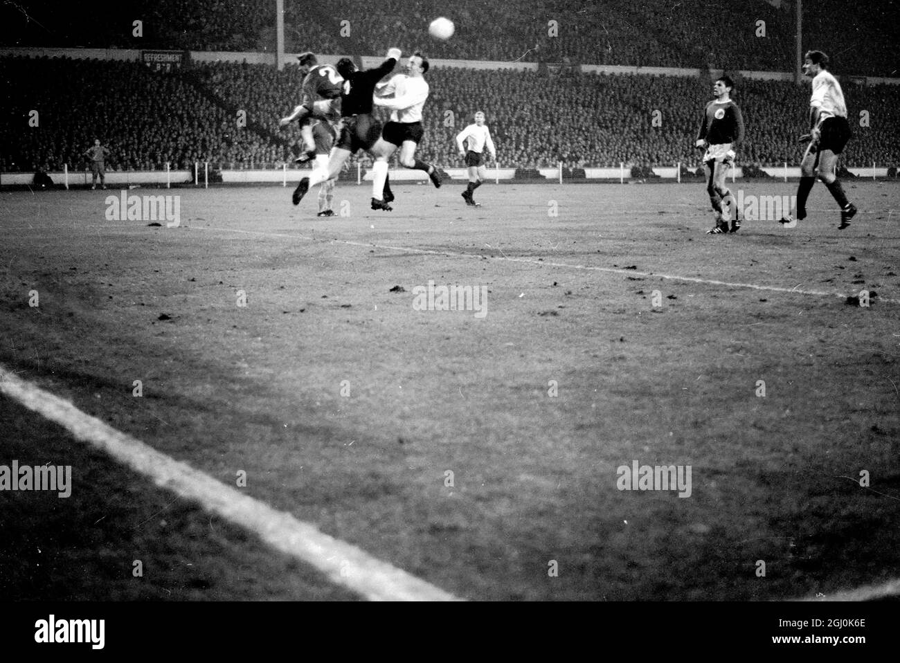 Wembley, Middlesex: England und Leeds United Spieler Jackie Charlton; (Mittelhälfte). Der westdeutsche Torhüter Hans Tilkowski wird heute Abend während des Internationalen Fußballvereins im Empire-Pool zwischen Deutschland und England in Aktion gezeigt. Das Spiel wurde bei starkem Regen und bei schlaffen Bedingungen gespielt; es wurde von einer Menge beobachtet, die auf 50,000 geschätzt wurde. 23. Februar 1966 Stockfoto