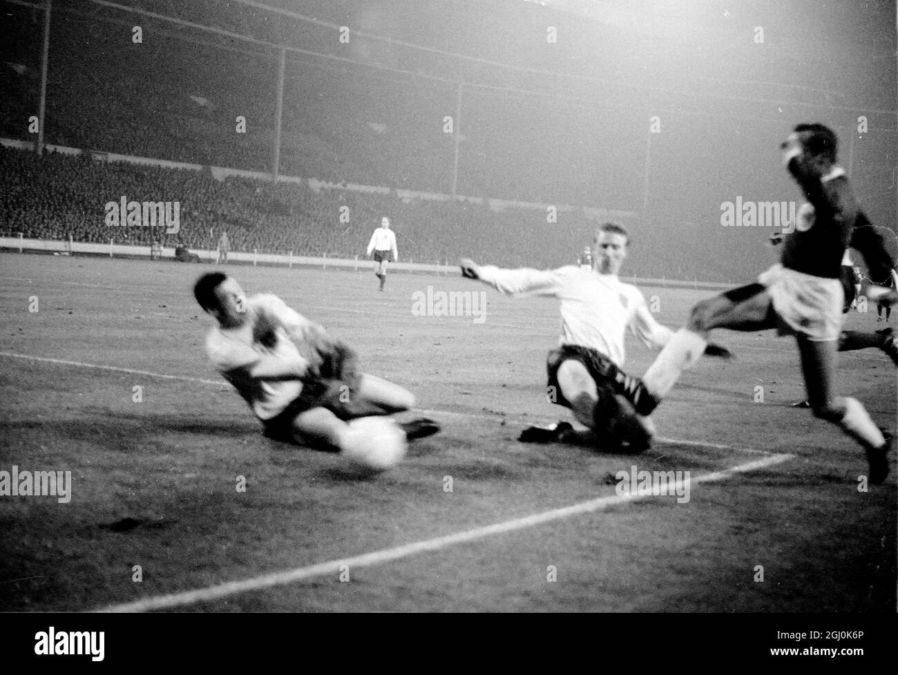 Wembley, Middlesex: England und Leicester City Torwart G. Banks; (links); und Leeds United Spieler Jackie Charlton (Mitte-Hälfte) (Mitte) und Westdeutschland und F.C. Der Kölner Spieler H. Hornig (außen links) wird während des Association International Match im Empire Pool zwischen Deutschland und England in Aktion gezeigt, während des Spiels sind sie im Einsatz. Das Spiel wurde bei starkem Regen und bei schlaffen Bedingungen gespielt; es wurde von einer Menge beobachtet, die auf 50,000 geschätzt wurde. Das Endergebnis für England lag bei 1:0, das Tor erzielte der Mitte-Vorwärts-Stiles in der 41. Minute. 23. Februar 1966 Stockfoto
