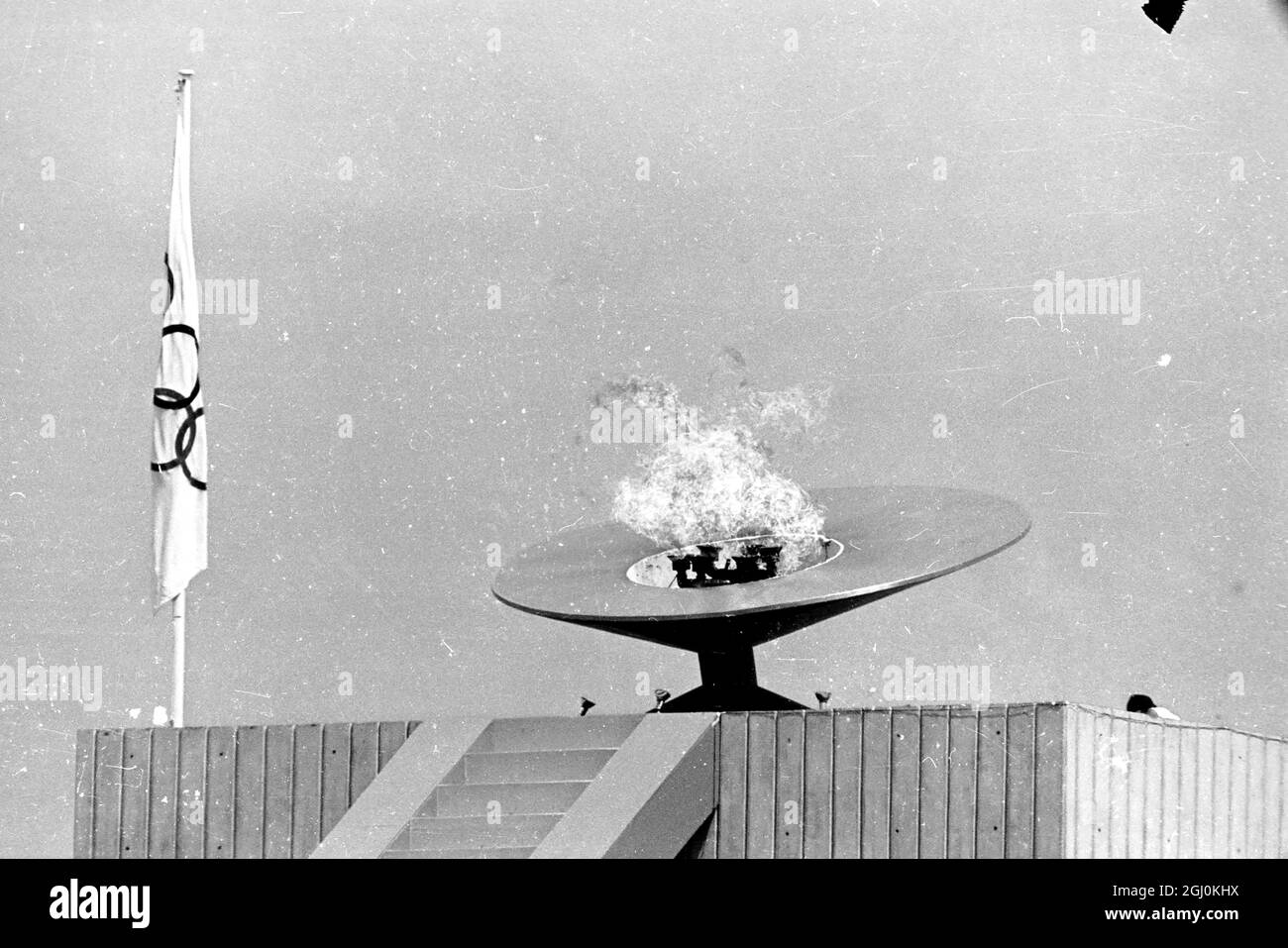 Mexiko-Stadt: Hoch über dem Olympiastadion brennt bei der Eröffnungsfeier der Olympischen Spiele 1968 die olympische Flamme. Die Flamme wurde von Enriqueta Basilio de Sotelo, dem mexikanischen Hürdenläufer, angezündet. Sie ist die erste Frau in der Geschichte der Olympischen Spiele der Moderne, die die Ehre hat. Die Zeremonie signalisierte den Beginn der Spiele am 12. Oktober 1968 Stockfoto