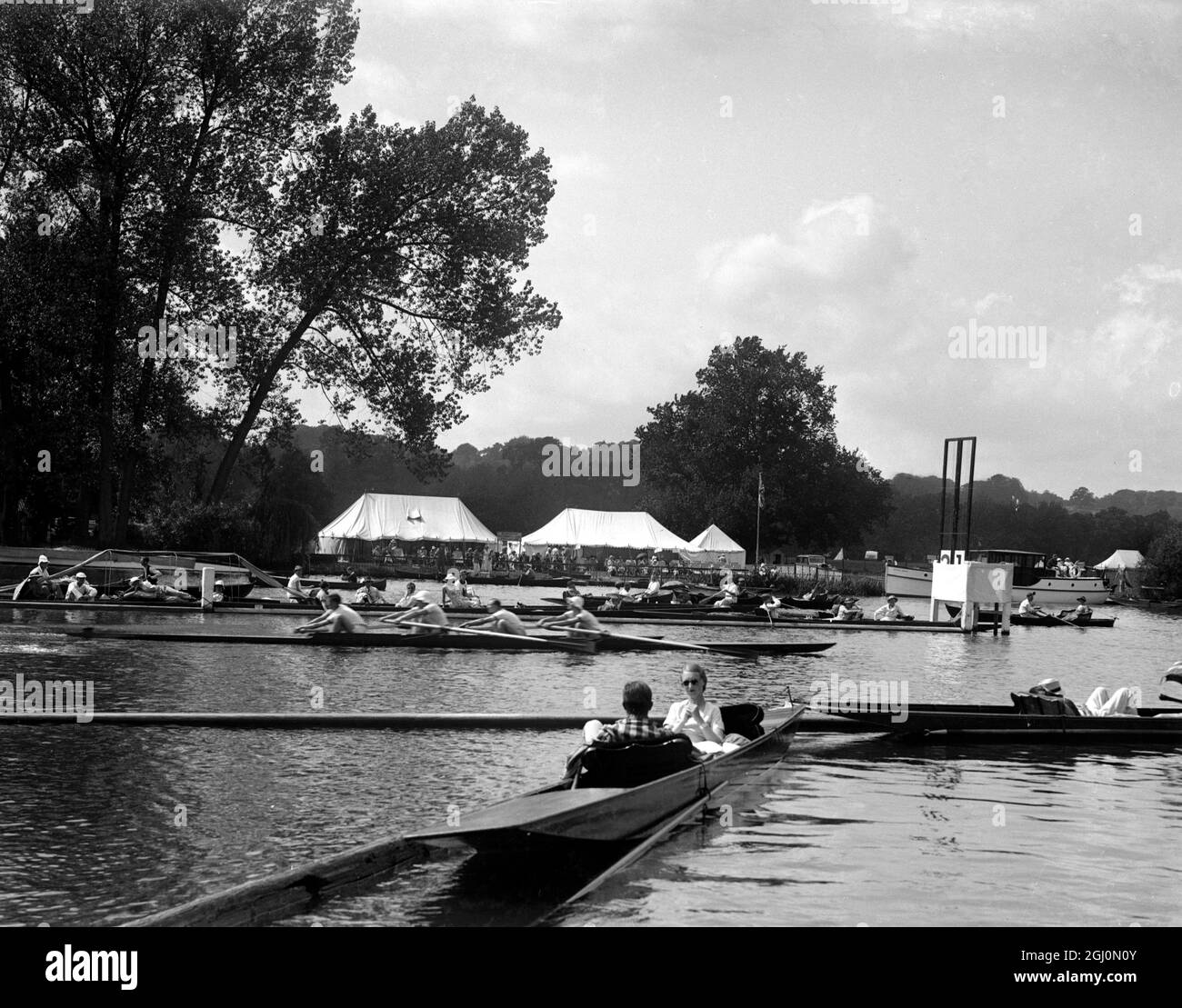 Zuschauer am Flussufer und in einem Punt während der Ruderrennen auf der Themse bei der Henley-Regatta , Henley - On - Thames , Oxfordshire . Ende der 40er Jahre, Anfang der 1950er Jahre Stockfoto