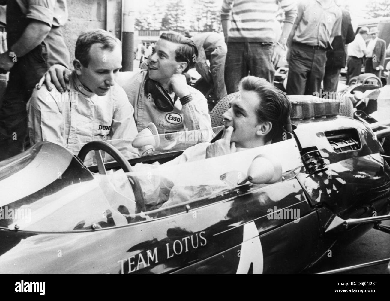 Der Nürburgring Lotus Teamfahrer Trevor Taylor bekommt von den Fahrerkollegen John Surtees und Jim Clark freundliche Ratschläge. 3. August 1963 Stockfoto