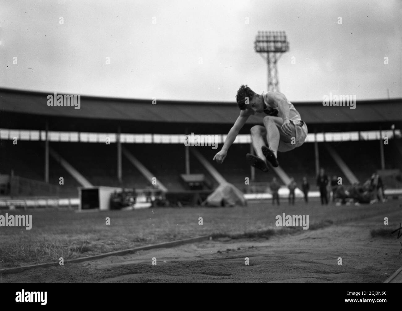 R C Bazley wird bei den Amateur Athletic Junior Championships in der White City, London, am 10. Juli 1948 gesehen, wie er seinen Weitsprung macht Stockfoto