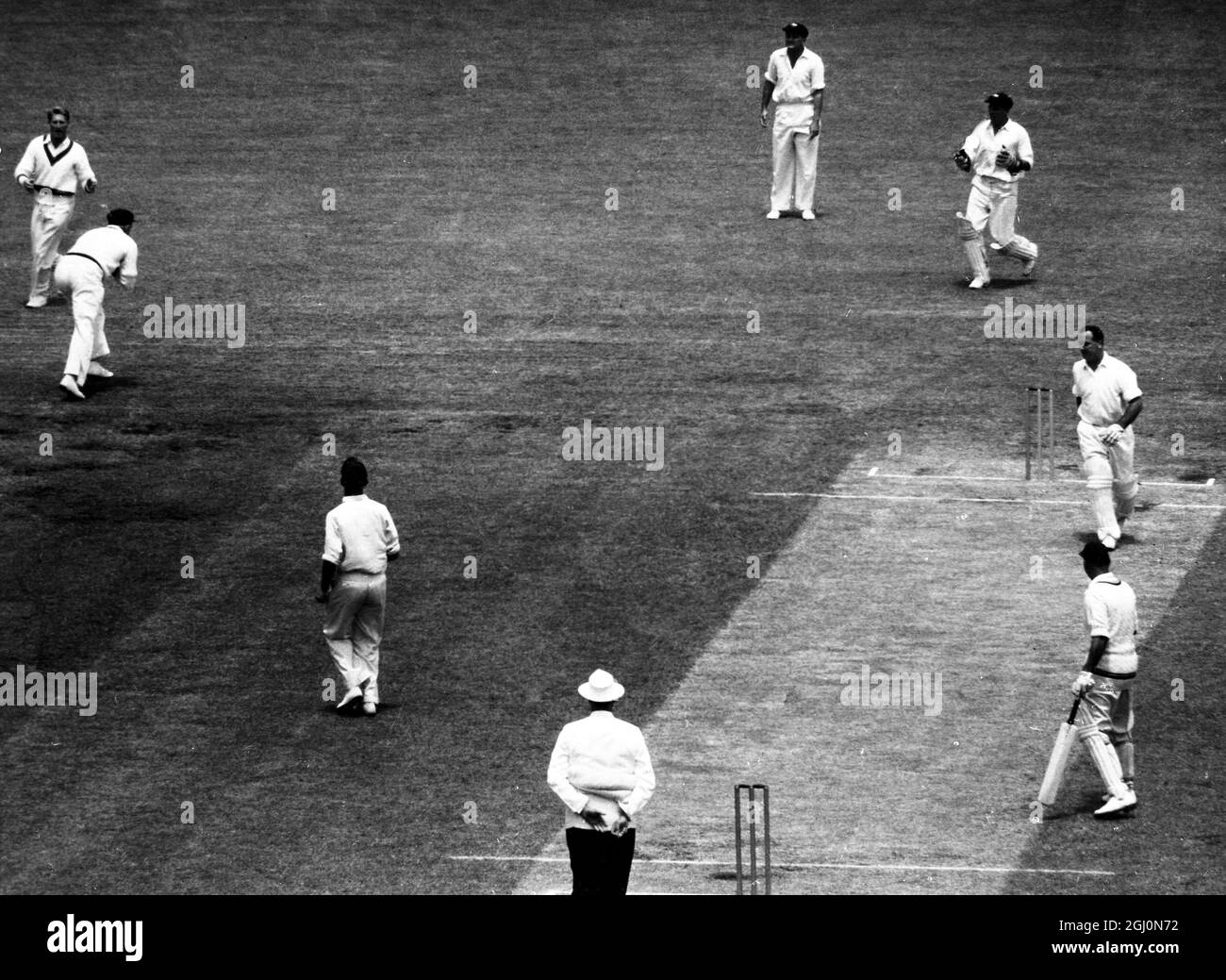 Der englische Cricketspieler Evans (links in der Mitte) wird von Davidson (rechts, gebogen) aus einem Ball von Meckiff (rechts vom Schiedsrichter) für vier Läufe im zweiten Testspiel England gegen Australien in Melbourne gefangen. Januar 1959 Stockfoto