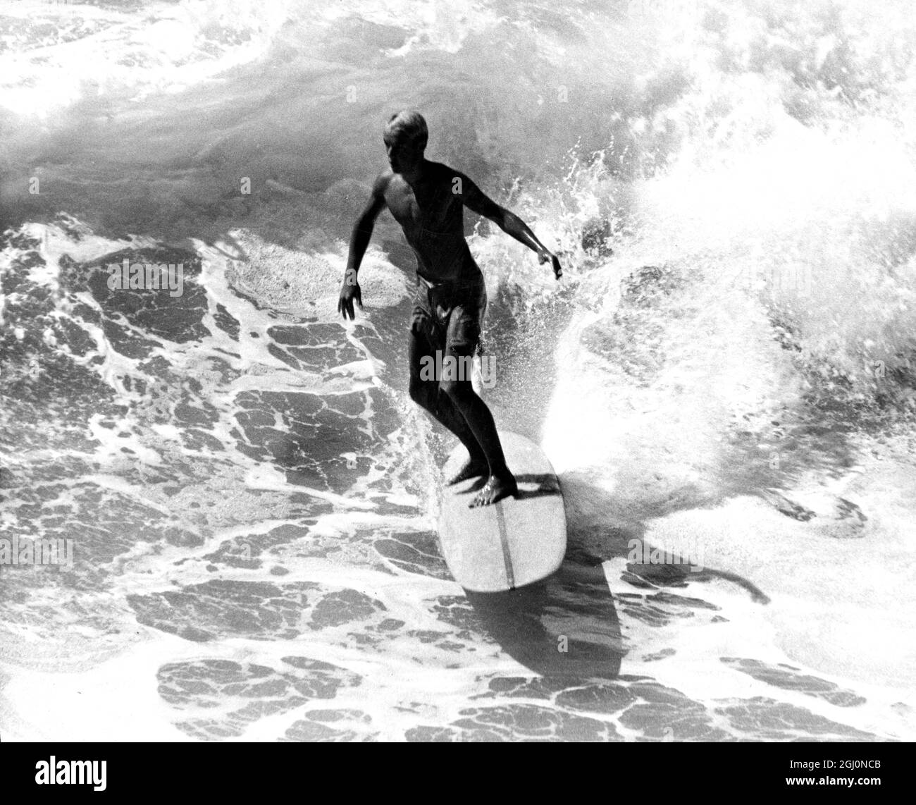 Ein Surfer, der eine Welle reitet. 60er Jahre Stockfoto