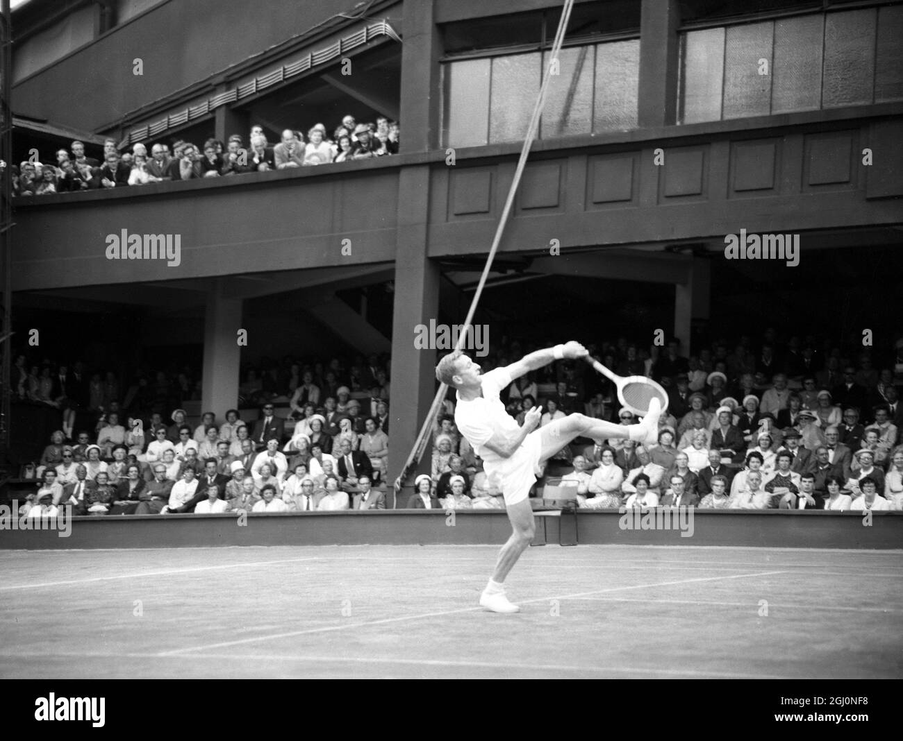 Der Wimbledon-Champion Rod Laver aus Australien behandelt die Zuschauer des Court One mit einer hohen Kickerblase, als er während seines Einzelschlags gegen den Briten Tony Pickard eine Rückkehr zurückschlägt. Laver gewann den 6-1 6-2 6-2 27. Juni 1962 Stockfoto