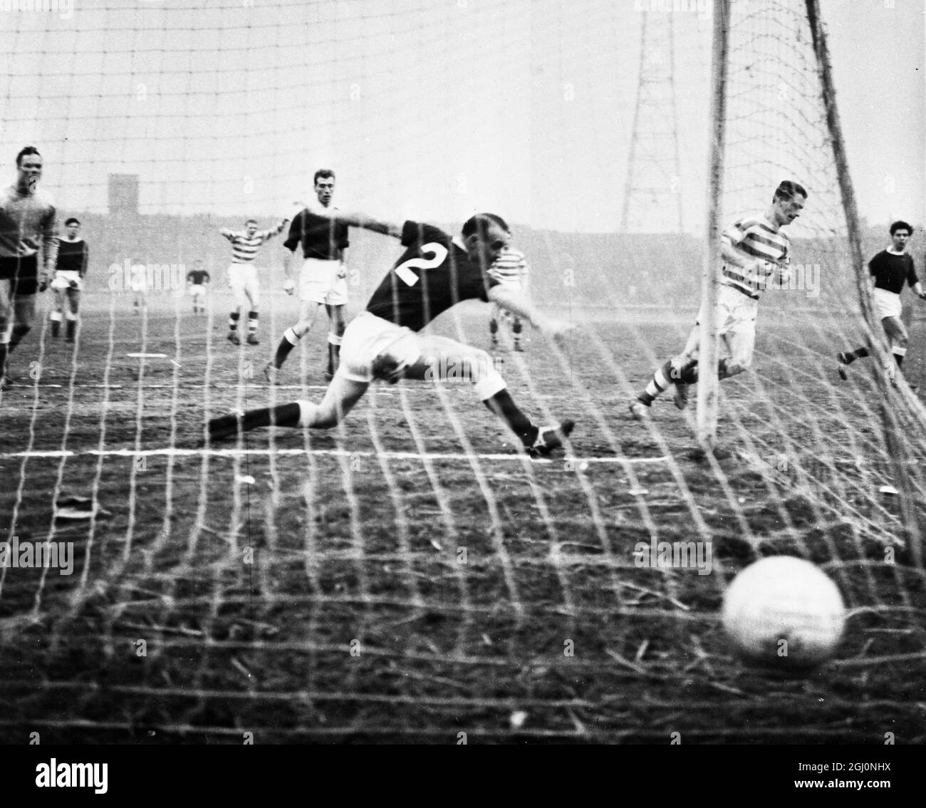 Glasgow; Chalmers (Streifen, rechts) erzielt das erste Tor von Celtic, während Eyemouth United's Right - Back Pherson ( No 2 ) den Ball während des ersten Round-Spiels des Scottish Cups nicht stoppen kann. Celtic gewann mit 3 - 0 . 13. Januar 1964 Stockfoto