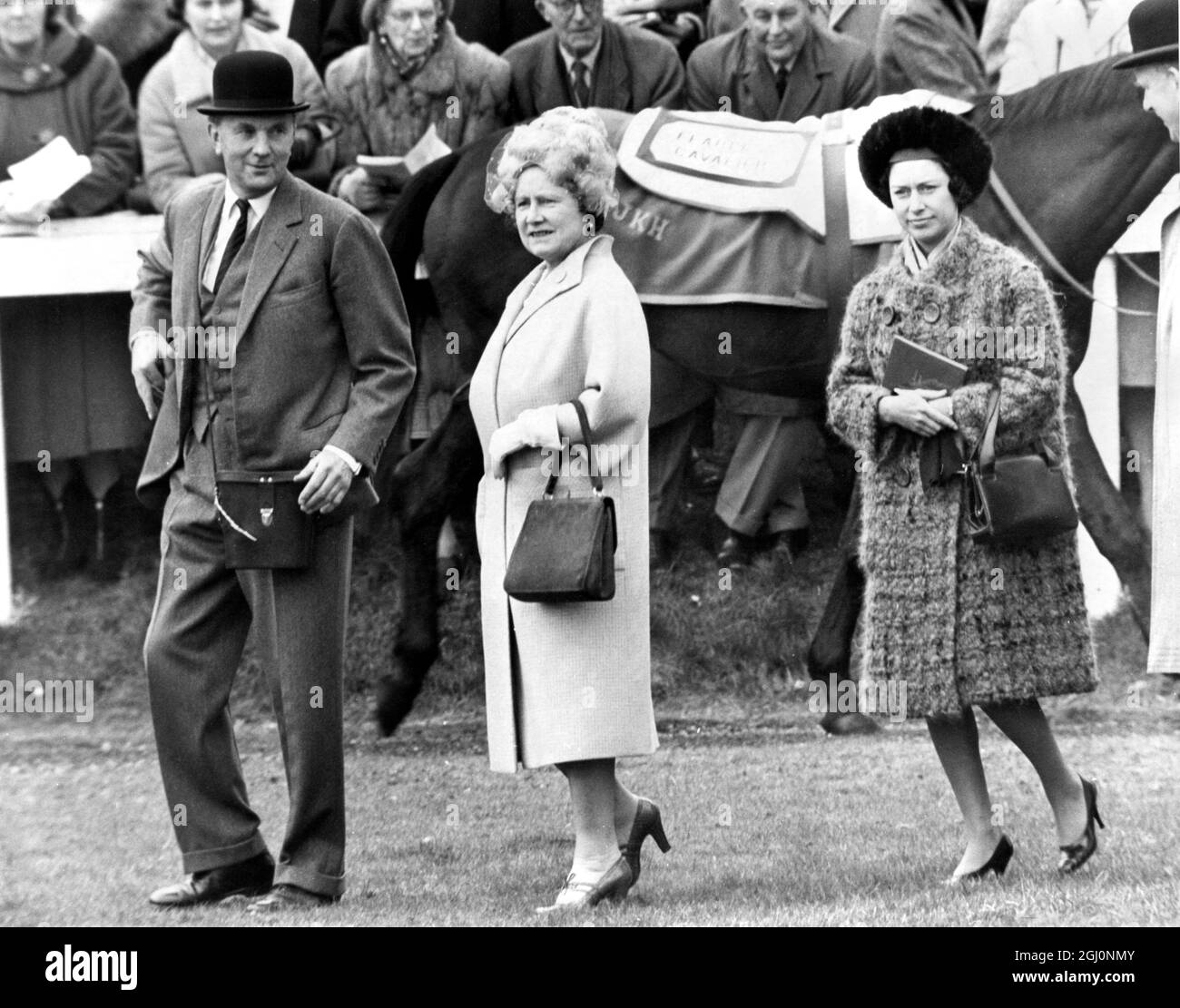 Die Königin Mutter und Prinzessin Margaret zu Fuß im Fahrerlager vor dem Grand National . Mit ihnen ist Peter Cazalet, der den Grand National Entrant der Königin Mutter '' The Rip '' ausgebildet hat. März 1965 Stockfoto