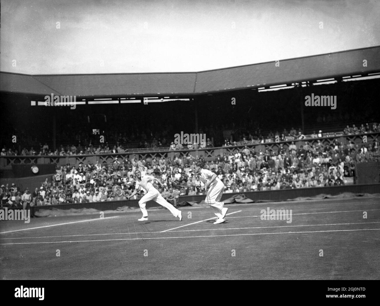 Pat Hughes und Raymond Tuckey , die Wimbledon-Meister trafen Jack Crawford und Adrian Quist aus Australien in den Doppelspielen des Davis Cup in Wimbledon , England . Hier gesehen Hughes und Tuckey laufen für den Ball 27. Juli 1936 Stockfoto