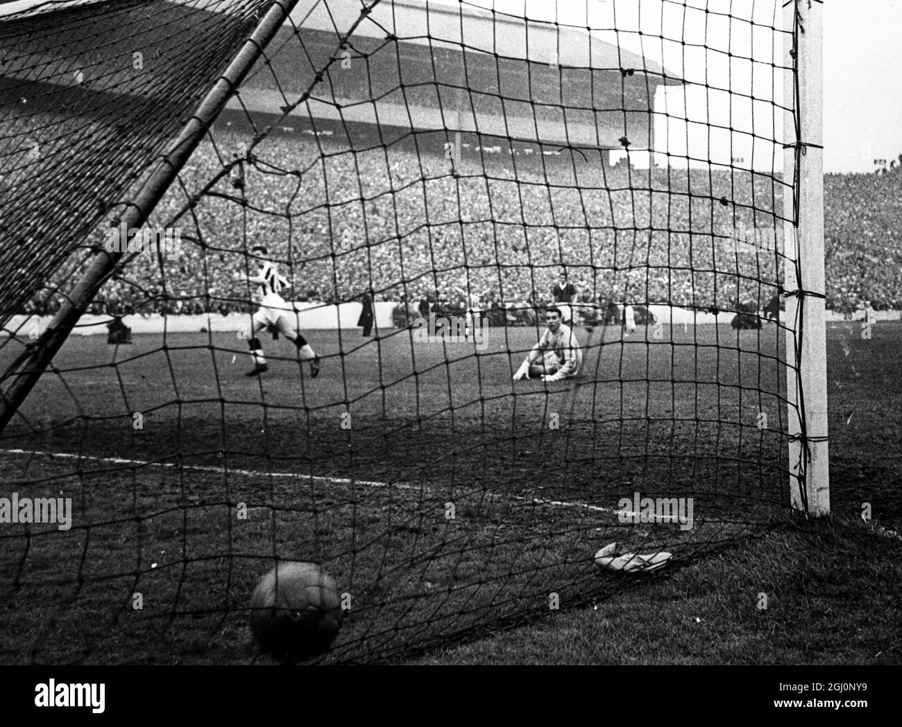 Der Ball ist im hinteren Teil des Netzes und Gerry Baker von St. Mirren (links) erzielte es, so dass es drei gegen Aberdeen im Scottish Cup Final in Hampden Park. Torhüter Martin sitzt hilflos auf dem Boden. Das Ergebnis war 3-1 . 26. April 1959 Stockfoto
