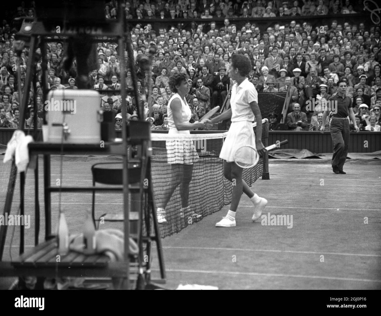 Die amerikanische Tennisspielerin, Althea Gibson, schüttelt sich nach ihrem Viertelfinalspiel im Einzel bei der Wimbledon Lawn Tennis Championship in London die Hände mit ihrer Landsfrau, Miss Shirley Fry. Miss Fry hat das Spiel gewonnen : 4 - 6 , 6 - 3 , 6 - 4 . Juli 1956 Stockfoto