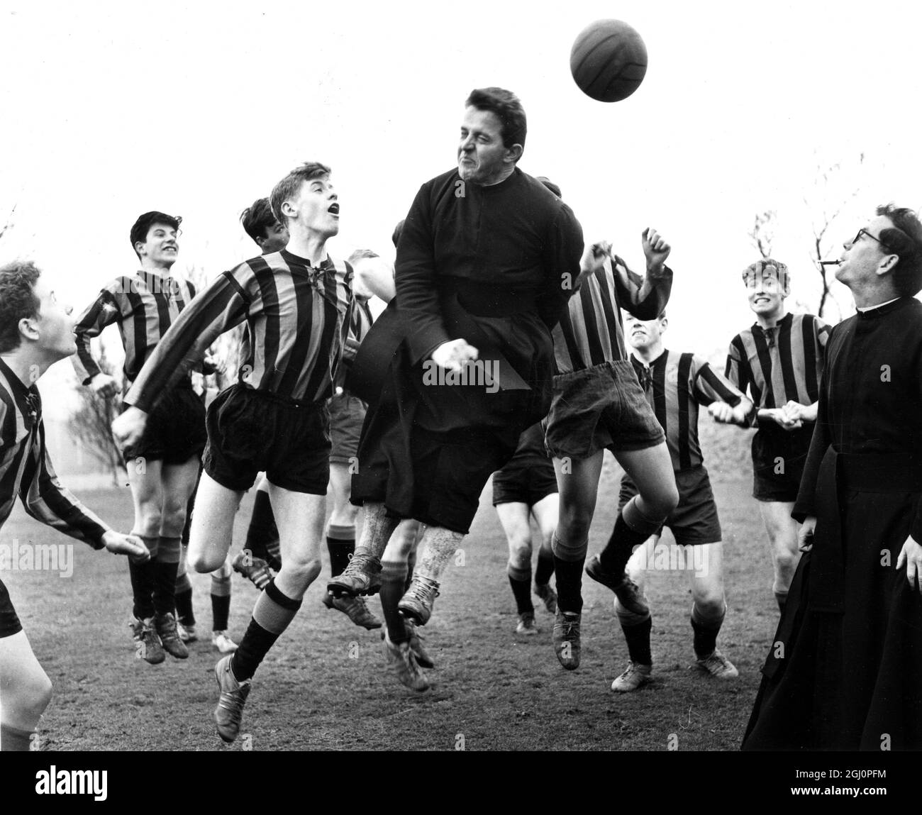 Pater John Pinkham und Pater Renze Ceresoli helfen ihren Schülern bei ihren Fußballtrainings und Schiedsrichterübungen, die hier bei einer Übungsstunde am St. Peter Claver Roman Catholic College in Mirfield, Yorkshire, England, zu sehen sind. Das Team ist so beliebt, dass sie Machees abstellen müssen, blau und schwarz gestreifte Trikots tragen müssen, ein besonderes Geschenk des berühmten italienischen Clubs Internationale Milano. 6. März 1965 Stockfoto