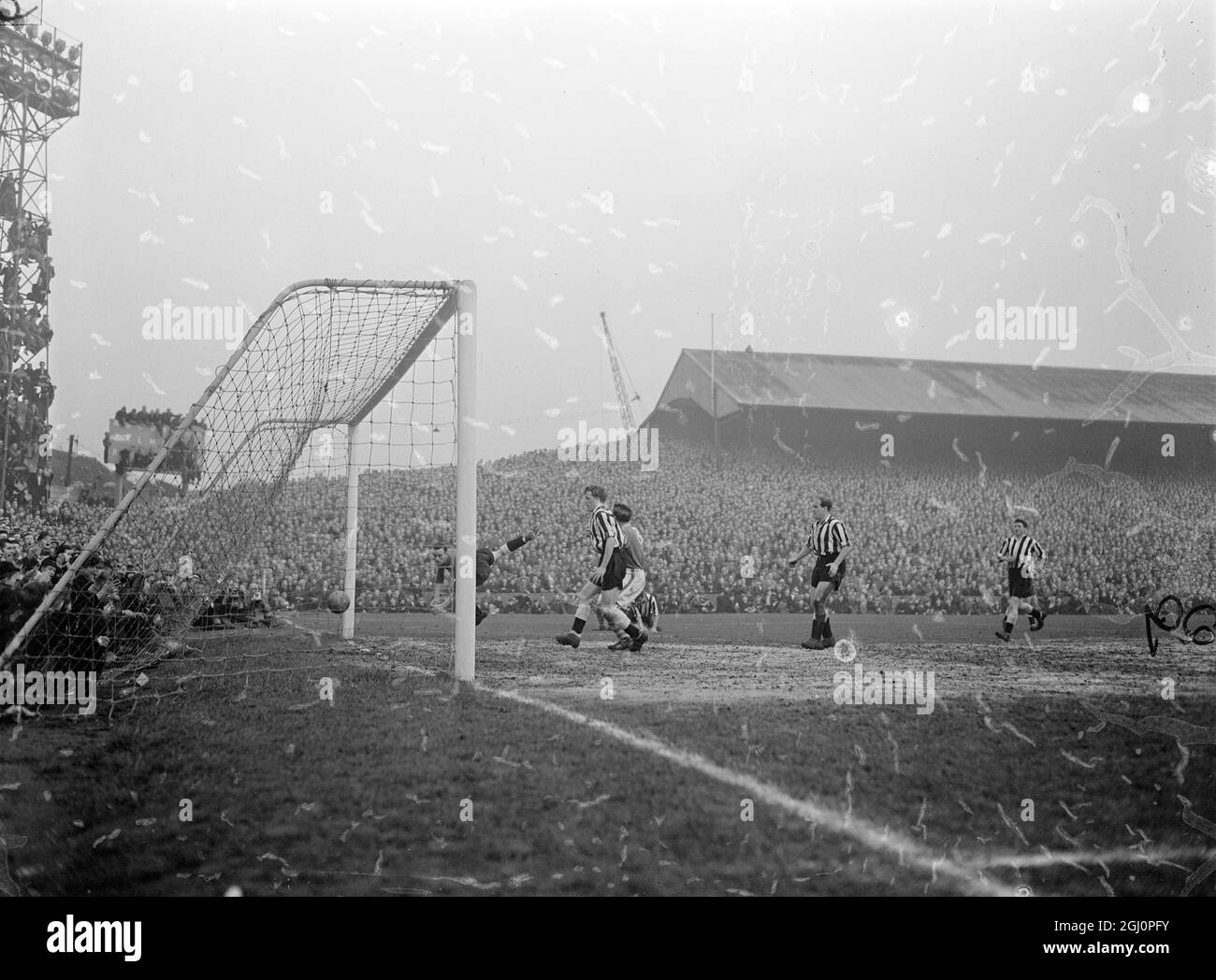 Trotz eines agilen Sprungs wird Newcastle United Torwart Simpson geschlagen, da Anslow (nicht abgebildet) Millwalls erstes Tor schießt, während der vierten Runde des FA Cup in Den. Das Spiel führte zu einem 2-1-Sieg für Millwall , mit Anslow erzielte beide Tore . 26. Januar 1957 Stockfoto