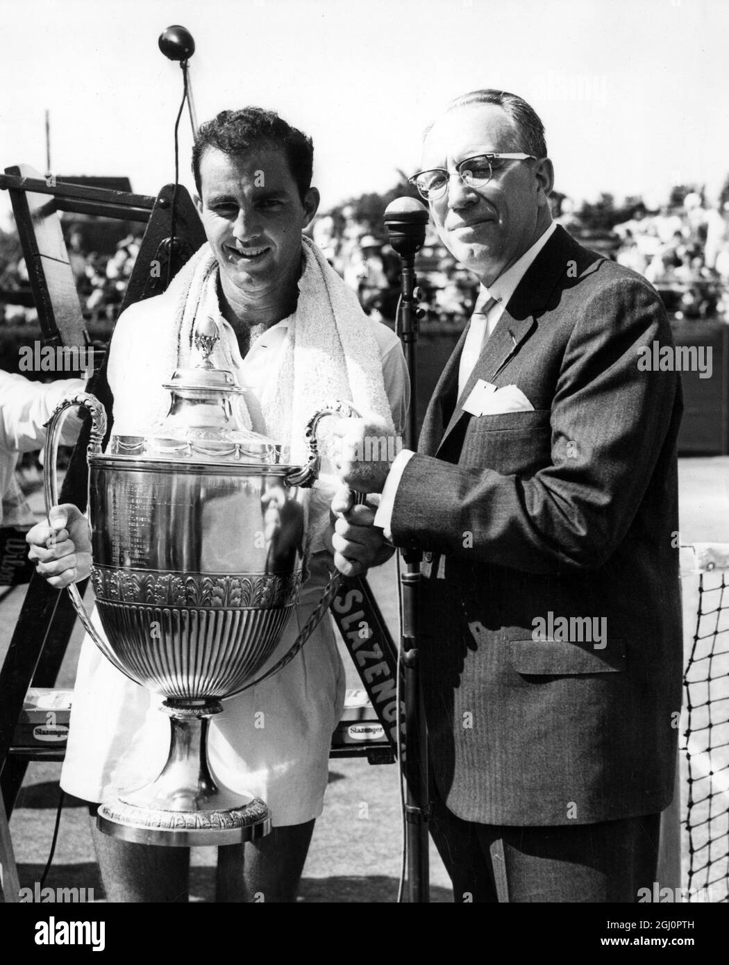 Rasentennis - das Finale der London Grass Court Championships im Queen's Club, London. Der australische Tennisspieler Bob Hewitt wird von Herrn G E Barnes , Präsident der United States Lawn Tennis Association, mit der Trophäe „Men's Singles“ ausgezeichnet. 24. Juni 1961 Stockfoto