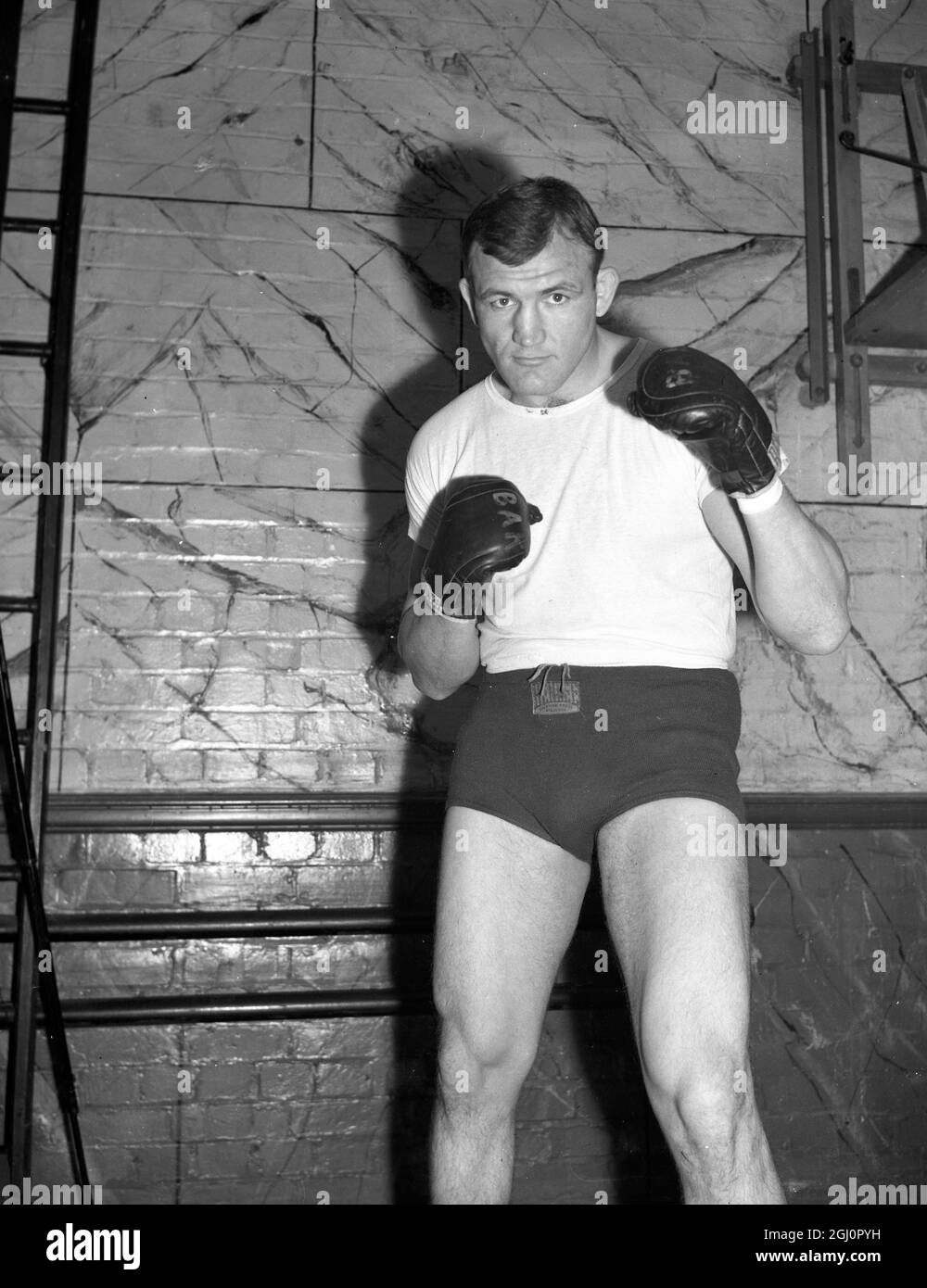 Joe Baksi , 26-jähriger polnisch-amerikanischer Schwergewicht aus Pennsylvania, der kürzlich in London Fight ankam, hat am 5. Novebmer in Harringay, London, ein strenges Training für seinen Kampf mit Freddie Mills absolviert. Foto-Shows: Joe Baksi kämpft mit den Fäusten in Jack Solomons Gymnasium in London 23. Oktober 1946 Stockfoto